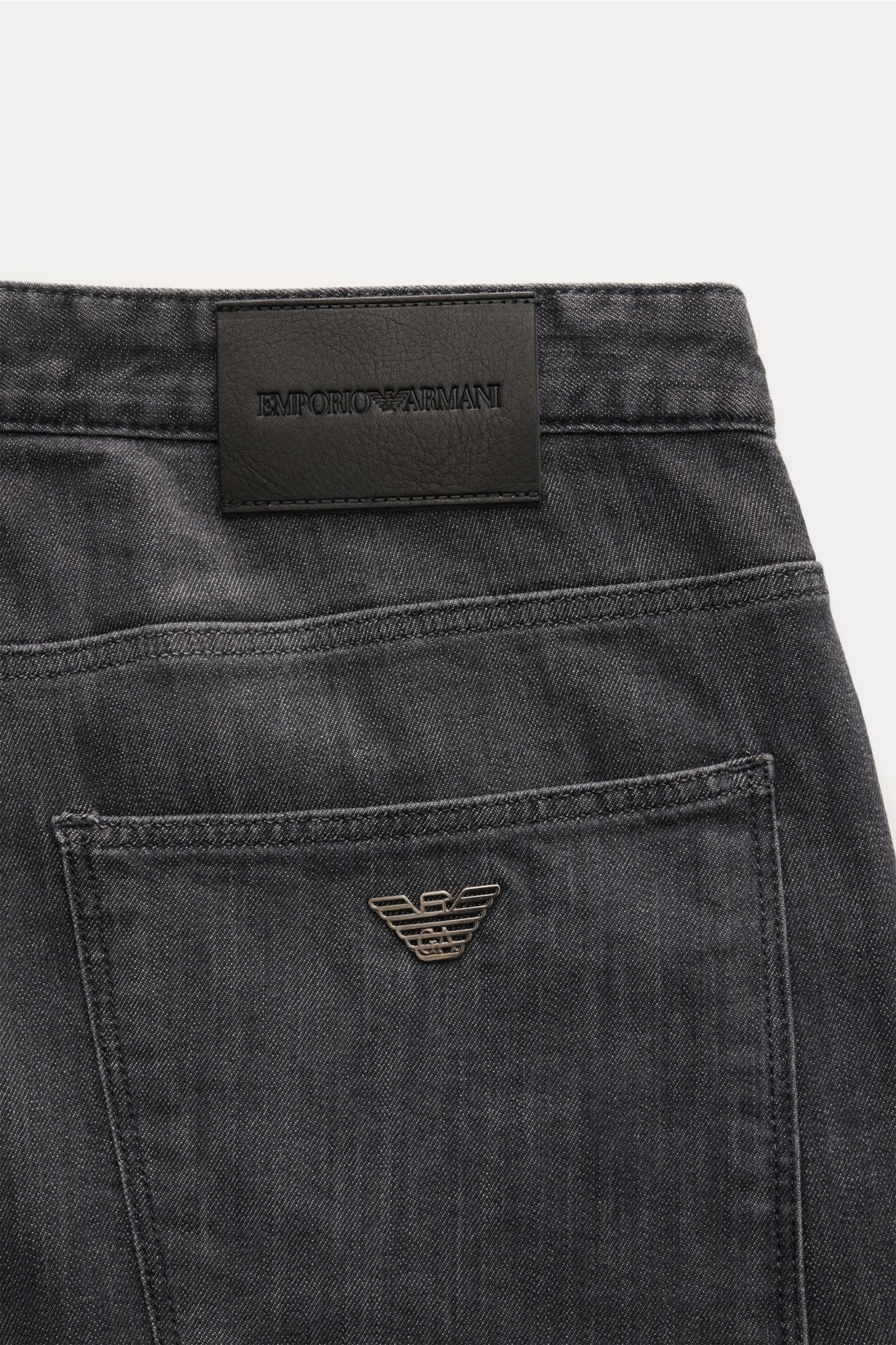 Emporio Armani Jeans dunkelgrau in Slim Fit, schmal zulaufend, mit Metall-Logo, Leather Patch, Five-Pocket-Stil, Zip Fly, leichte Waschung, weicher Griff, von hinten fotografiert.
