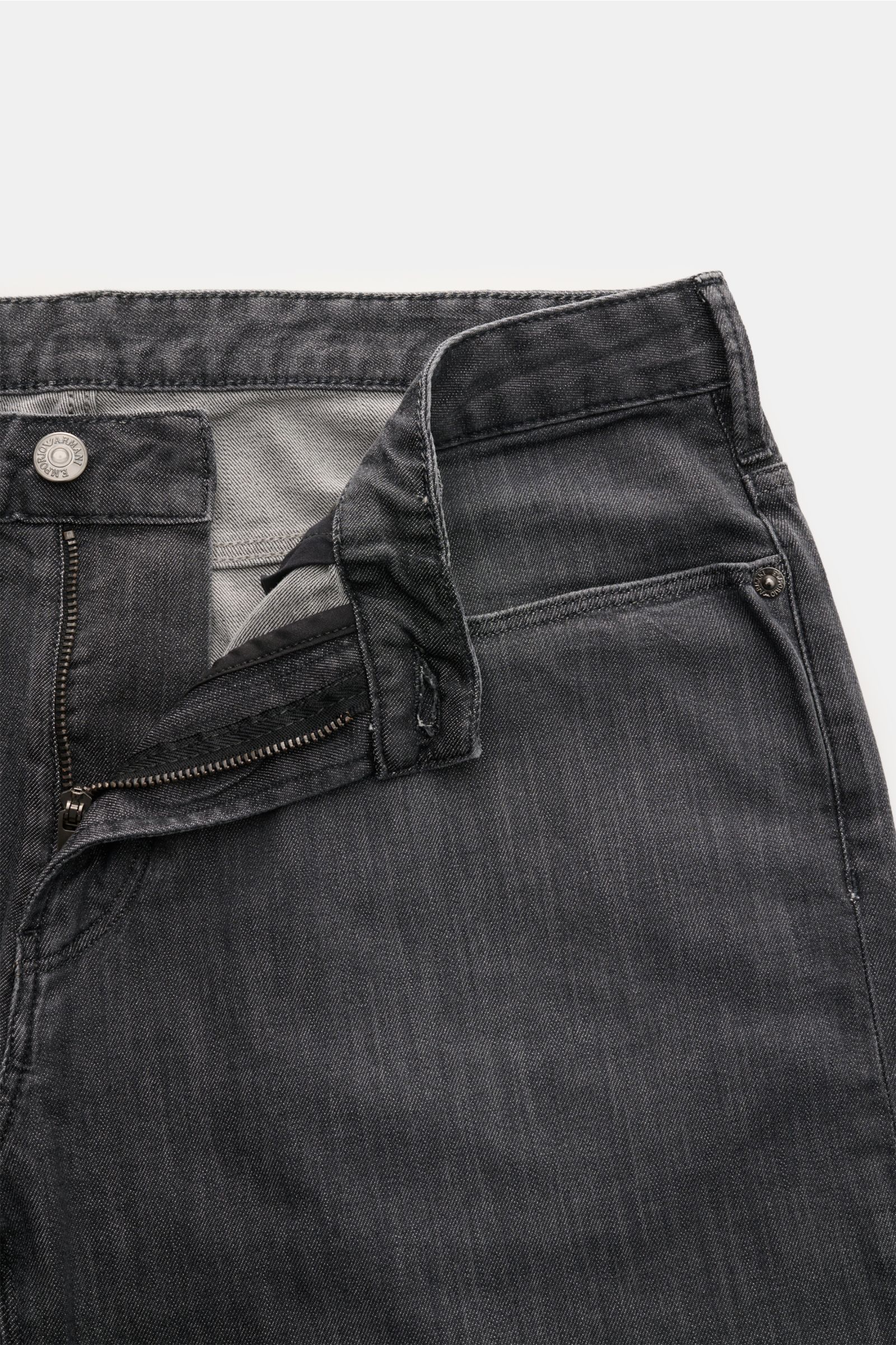 Emporio Armani Jeans dunkelgrau, Slim Fit, Five-Pocket-Stil, Zip Fly, Metall-Logos, Leather Patch, leicht elastisch, weich, von oben fotografiert.