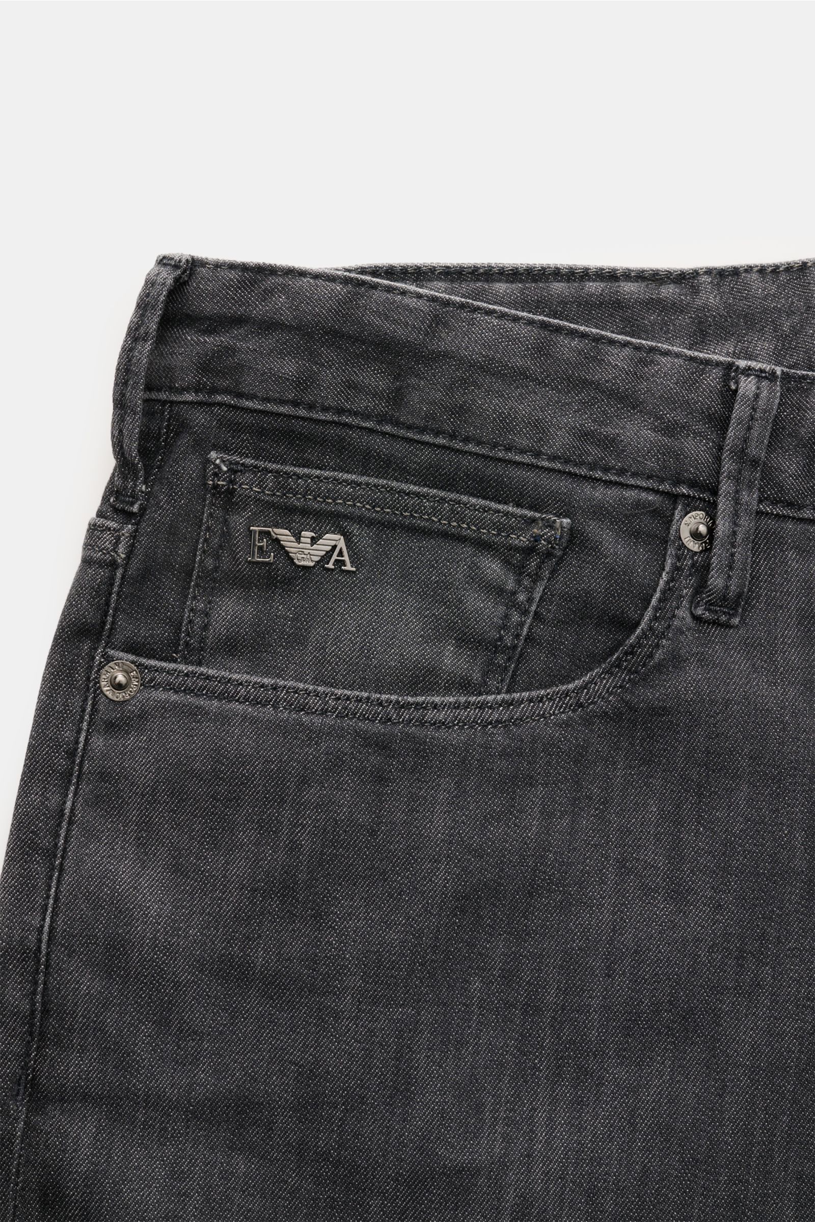 Emporio Armani Jeans dunkelgrau in Slim Fit, schmal zulaufend, Five-Pocket-Stil mit Metall-Logos, Leather Patch, Front nah fotografiert.