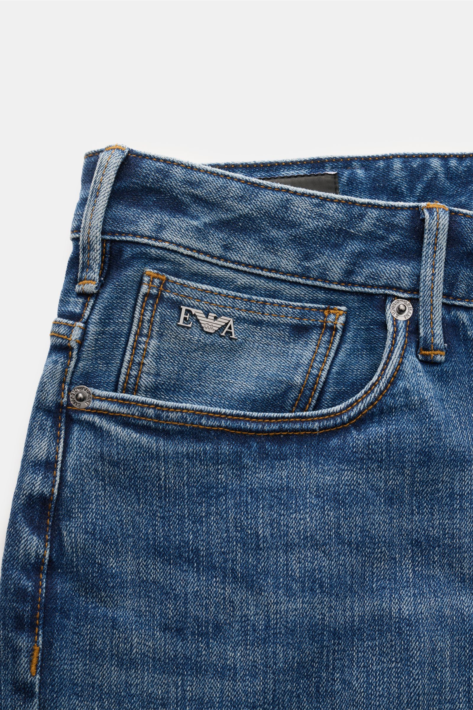 Emporio Armani Jeans blau, Nahaufnahme der schmal zulaufenden Slim Fit Denim mit Five-Pocket-Stil, Metall-Logos und authentischer Waschung.