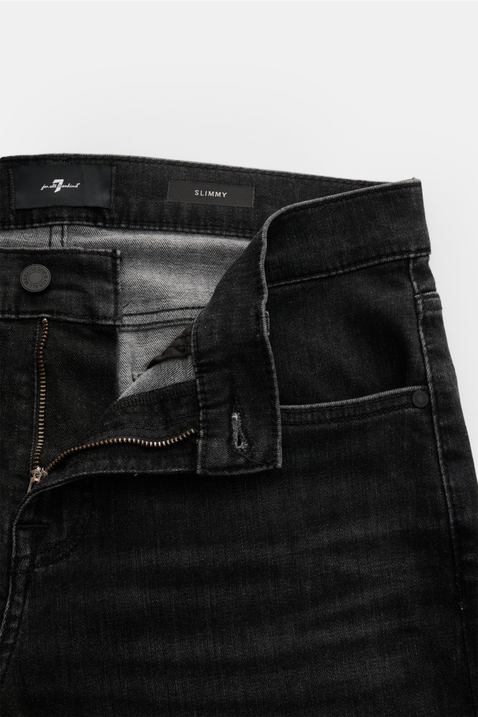 Close-up front view of 7 for all mankind Jeans 'Slimmy' dark grey with unzipped fly, showing slight stretch denim and small woven label inside.

Seven pairs of jeans should be enough to get you through life – that’s the philosophy of denim label 7 FOR 