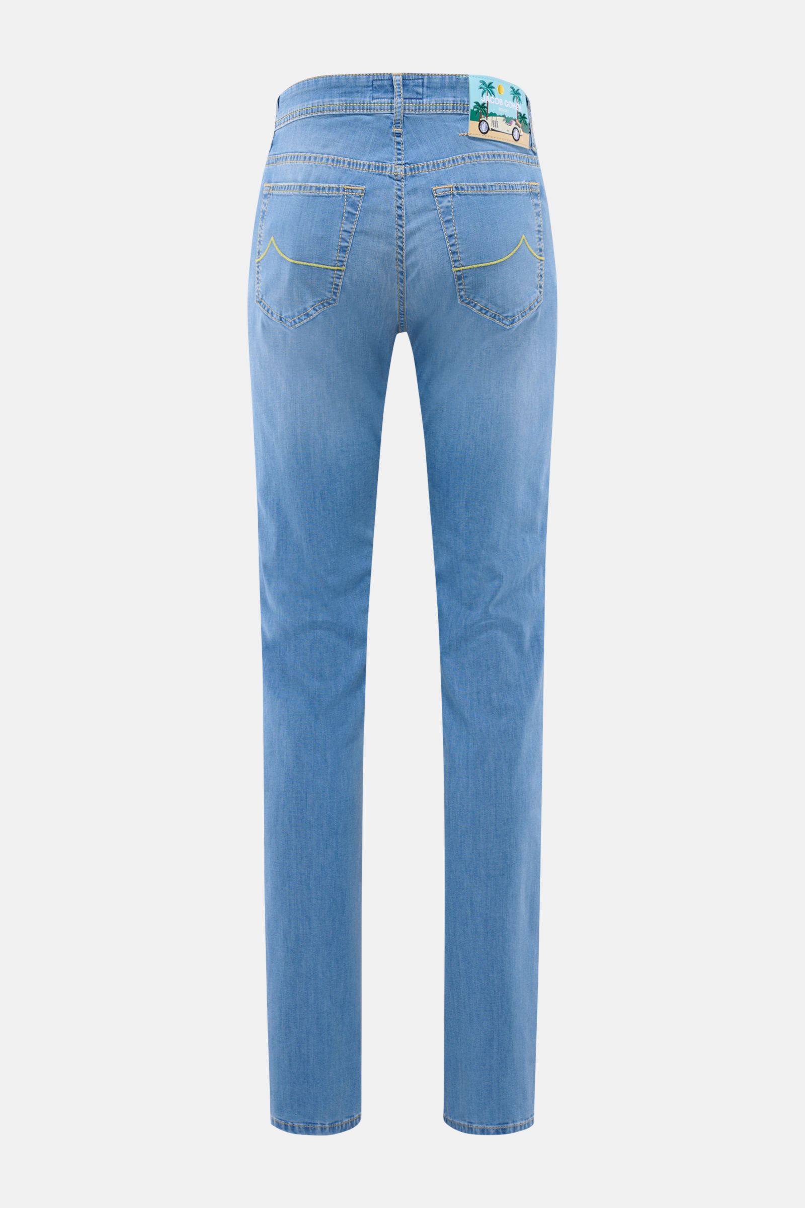 Rear view of Jacob Cohen Jeans 'Bard' blau in light blue denim with elastic cotton-viscose blend, slim fit, tapered legs, button fly, five-pocket style, yellow stitching on back pockets, and a leather patch with palm tree motif.
