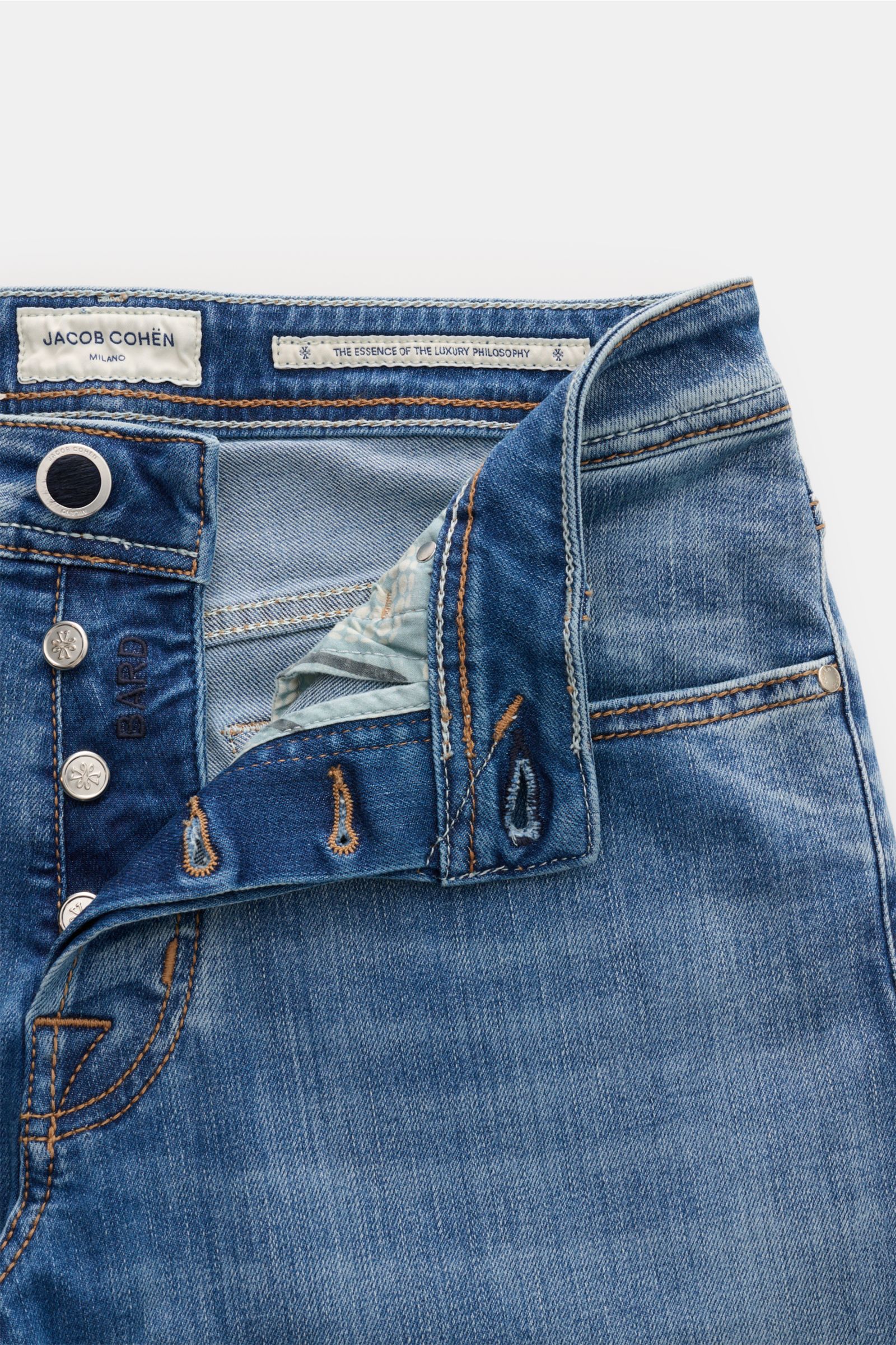 Jacob Cohen Jeans 'Bard' graublau, Nahaufnahme der geöffneten Front mit Button Fly, weichem Denim, Used-Waschung und Label-Patches.