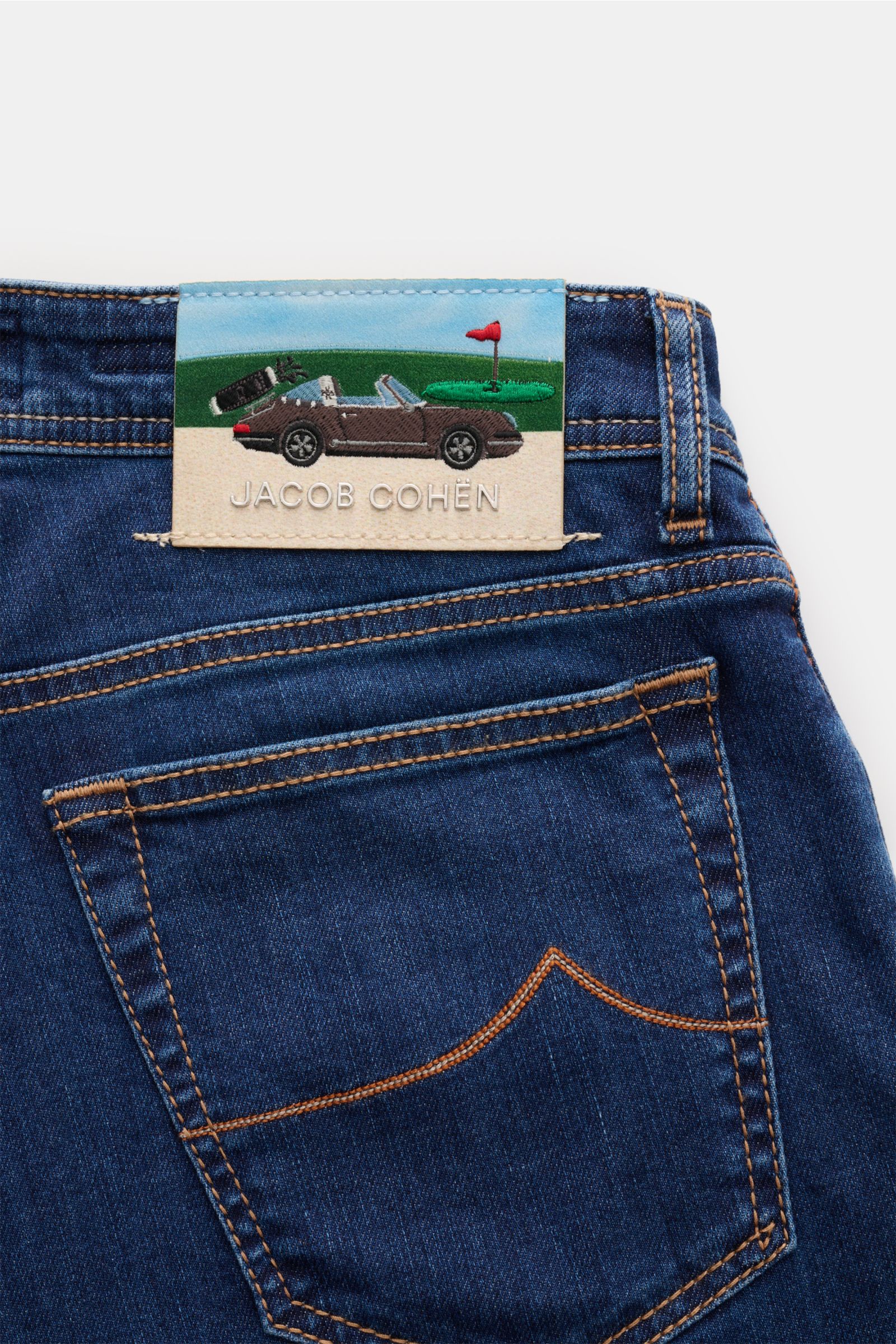 Jacob Cohen Jeans 'Bard' navy in elastischer Baumwolle, Detailaufnahme von hinten auf Gesäßtasche mit Porsche-Golf-Patch im Five-Pocket-Stil.