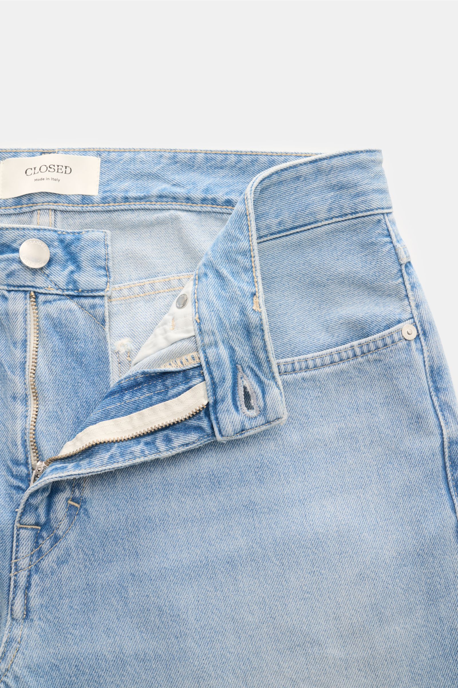 Close-up von Closed Jeans 'Cooper' hellblau mit geöffnetem Zip Fly, Five-Pocket-Stil, authentischer Used-Waschung, leichter Baumwolle.