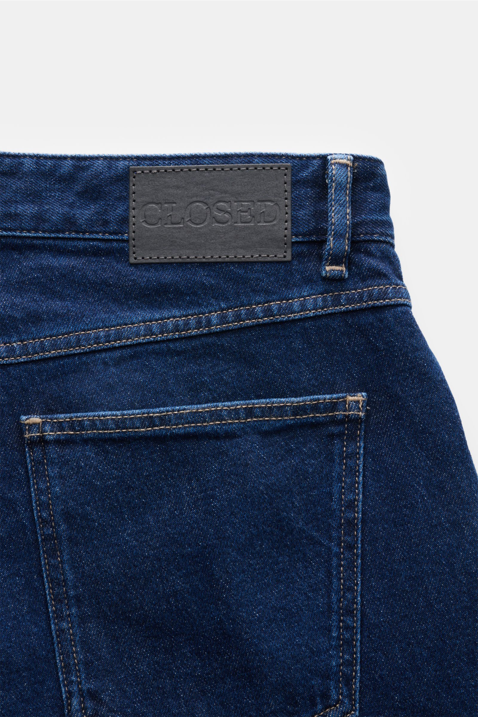 Close-up rear view of Closed Jeans 'Cooper' navy showing authentic Used wash, five-pocket style, zip fly, and leather patch with CLOSED logo.