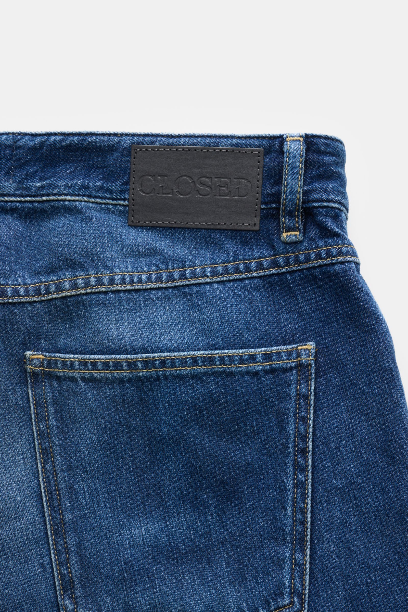 Close-up rear view of Closed Jeans 'Cooper' dunkelblau showing denim pure cotton, soft feel, regular fit, slightly tapered, authentic used wash, five-pocket style, zip fly, typical CLOSED label, and back patch.