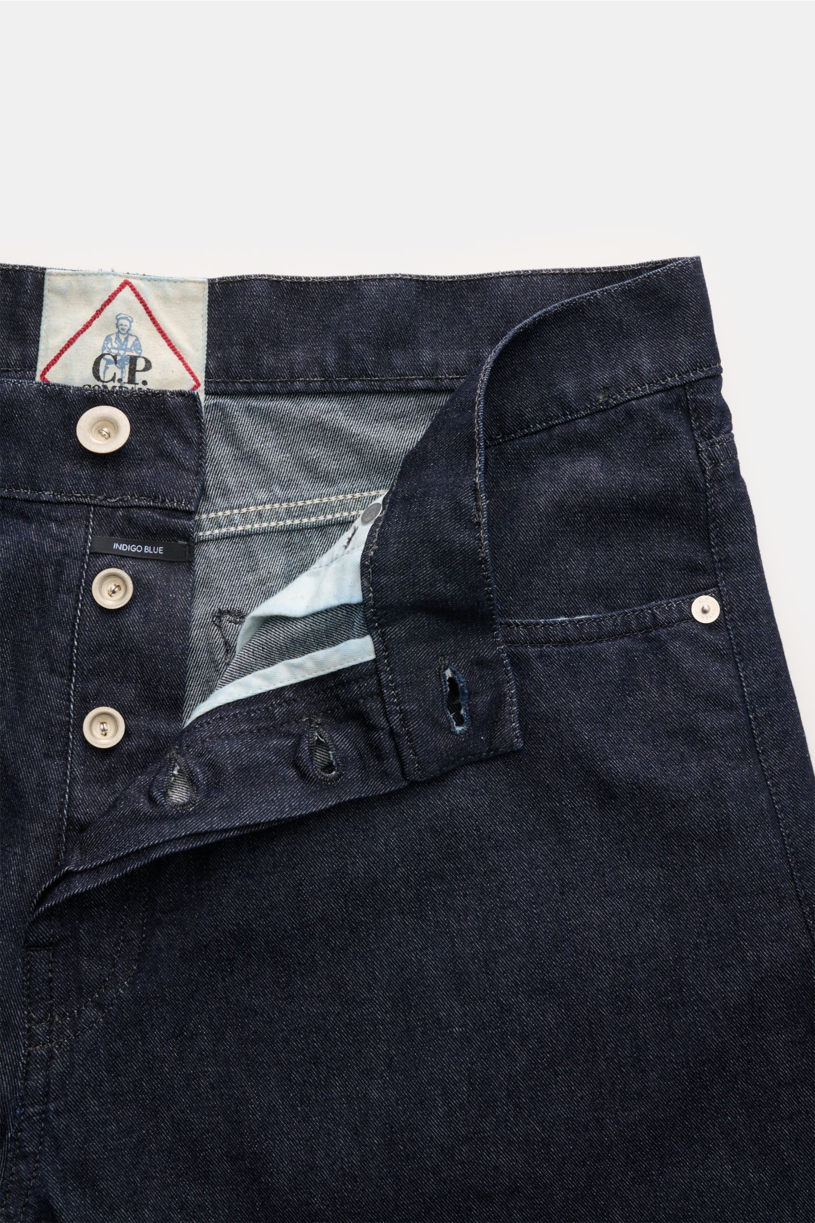 Close-up front view of C.P. Company Jeans navy with button fly open, showing pure cotton fabric and leather patch detail. Timeless companion: These jeans in a tapered fit by C.P. COMPANY have a casual silhouette and a premium finish. Pure cotton, slightly