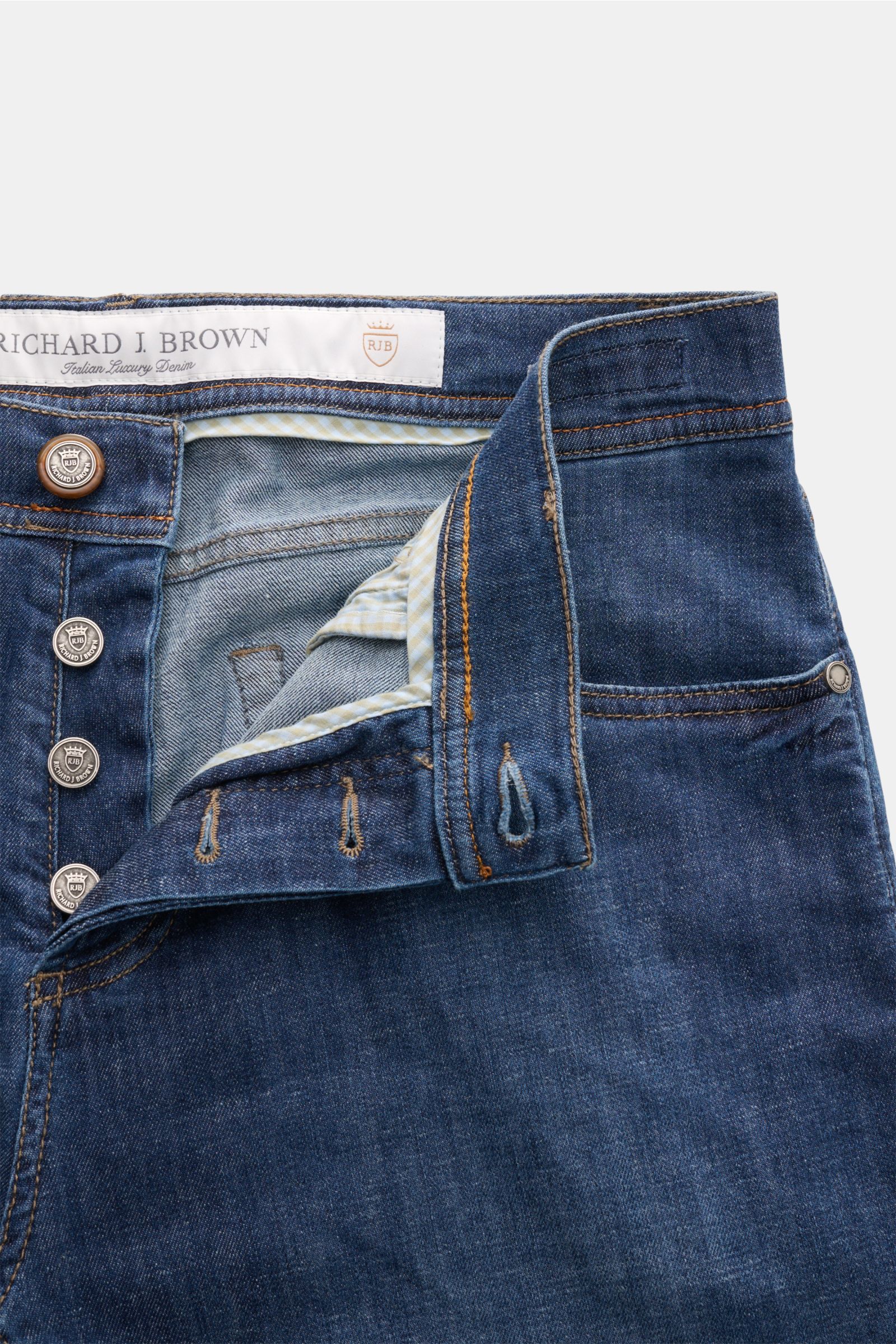 Close-up front view of Richard J. Brown Jeans 'Tokyo' dark blue, featuring button fly, five-pocket style, coin pocket with logo stitching, and leather patch, made of cotton, linen, and lyocell blend with a slim, tapered fit.

Description: Timeless skill i