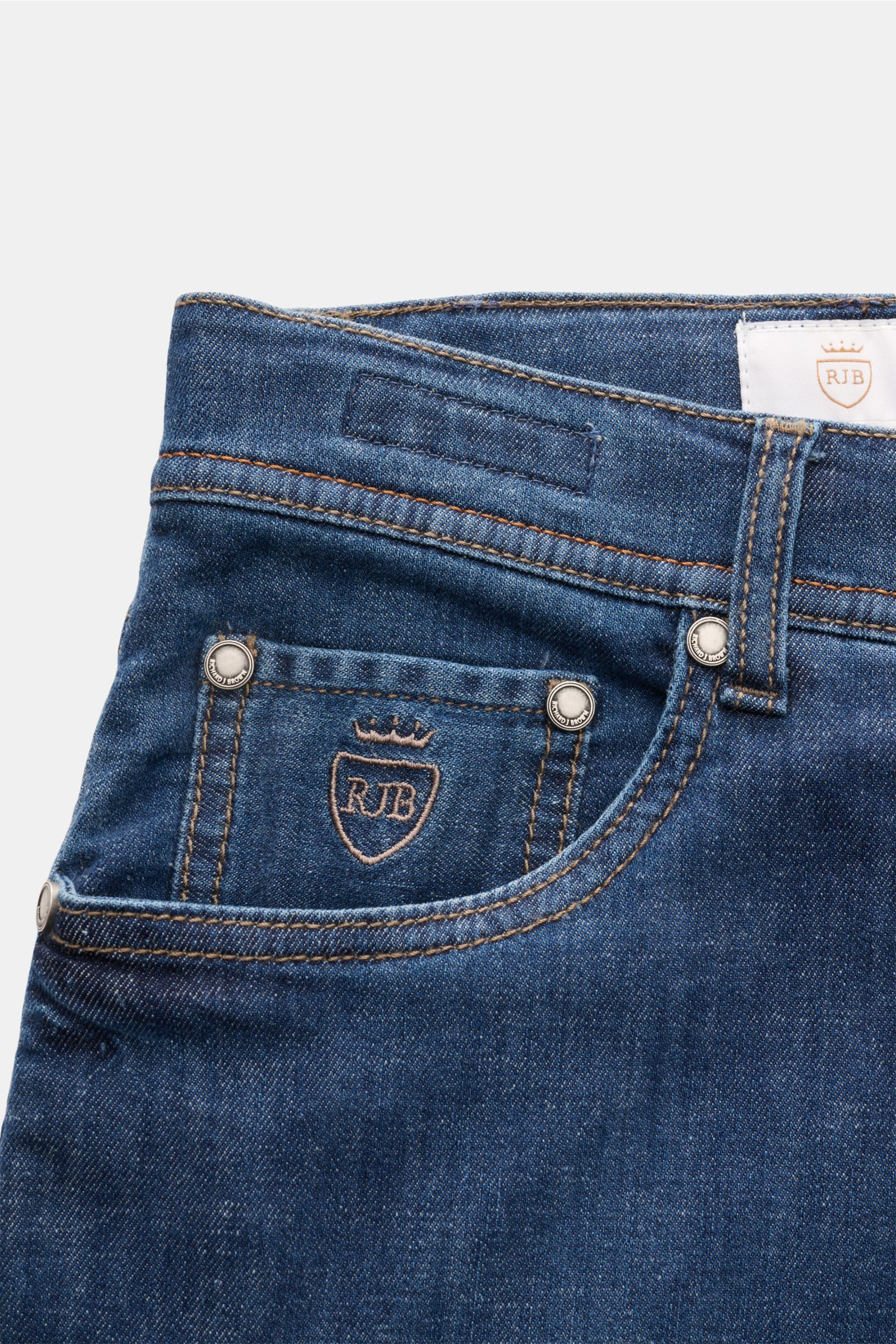 Close-up front view of Richard J. Brown Jeans 'Tokyo' dark blue showing the coin pocket with logo stitching, button fly, and leather patch, made of slightly elastic cotton, linen, and lyocell denim with a soft feel, slim fit, tapered cut, and five-pocket 