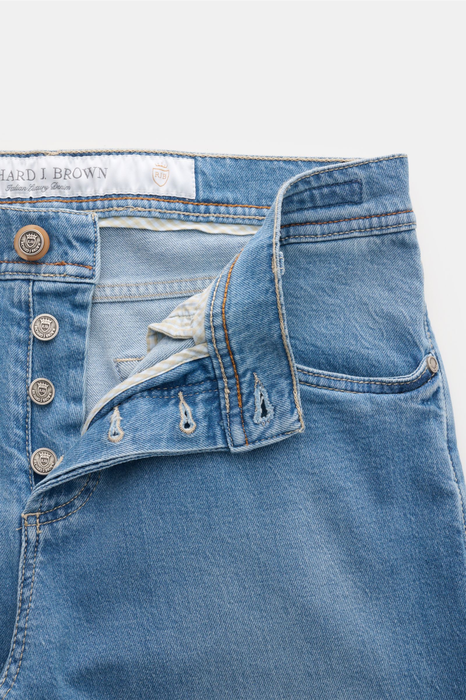 Nahaufnahme der geöffneten Richard J. Brown Jeans 'Tokyo' hellblau mit Button Fly, Five-Pocket-Stil, Münztasche mit Logo-Stitching, Leather Patch, aus Baumwolle und Tencel, leicht elastisch, Slim Fit, sehr schmal zulaufend, weicher Griff, von oben fotogra