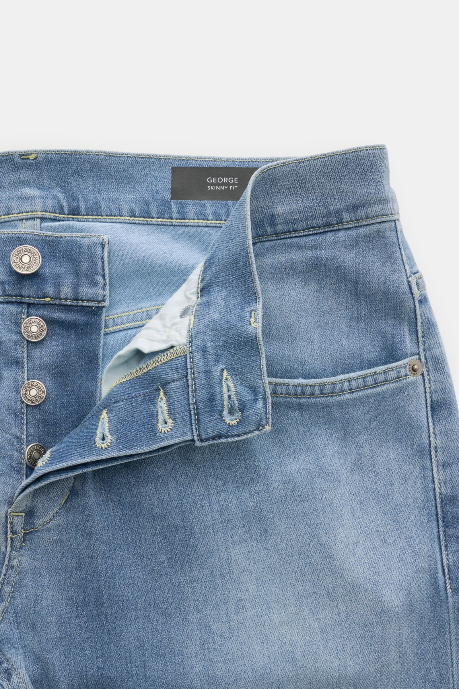 Dondup Jeans 'George' rauchblau, Skinny Fit, elastischer Denim, Used-Waschung, Button Fly, Five-Pocket-Stil, schräg von oben fotografiert.