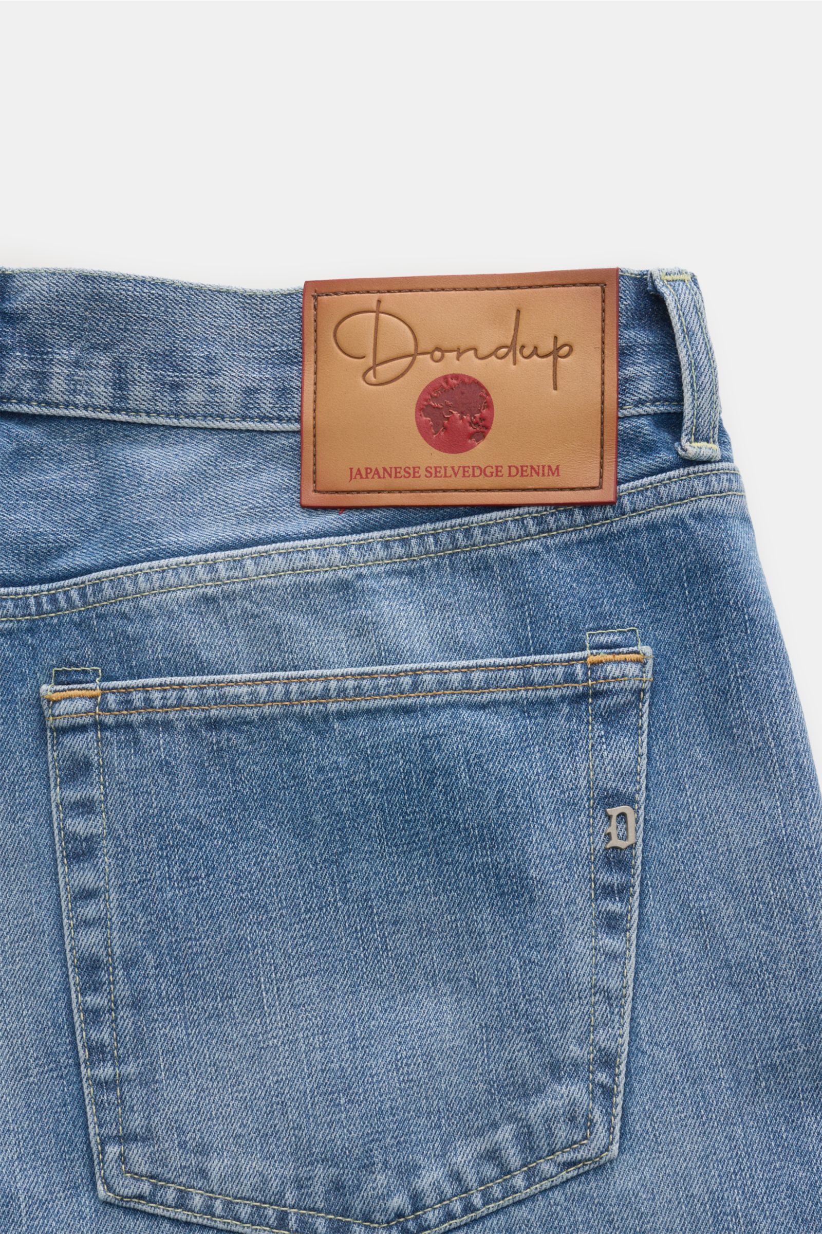 Close-up rear view of Dondup Jeans 'Bray' rauchblau showing Japanese selvedge denim, leather label, and metal initial on soft, authentic washed fabric.