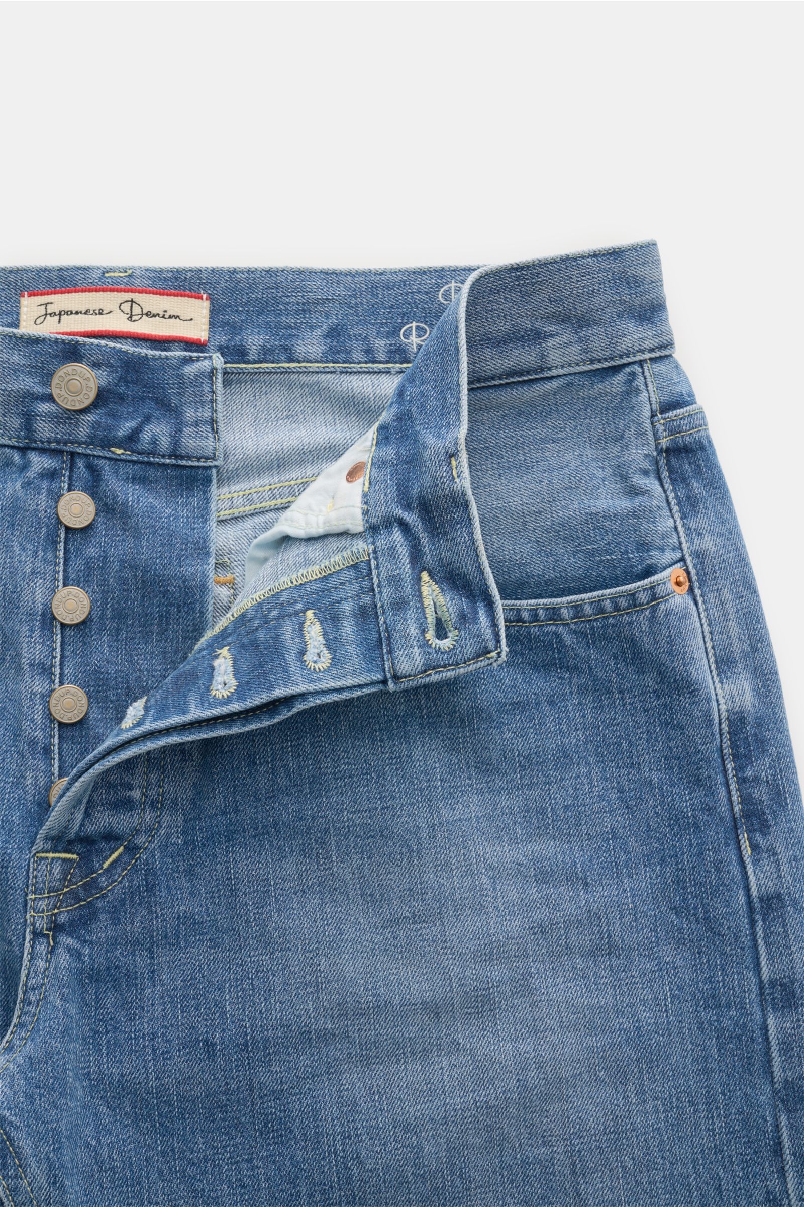 Close-up front view of Dondup Jeans 'Bray' rauchblau in Japanese Selvedge Denim with button fly, authentic wash, subtle distressed details, and five-pocket style. Soft cotton fabric with small metal initial and inside DONDUP label.