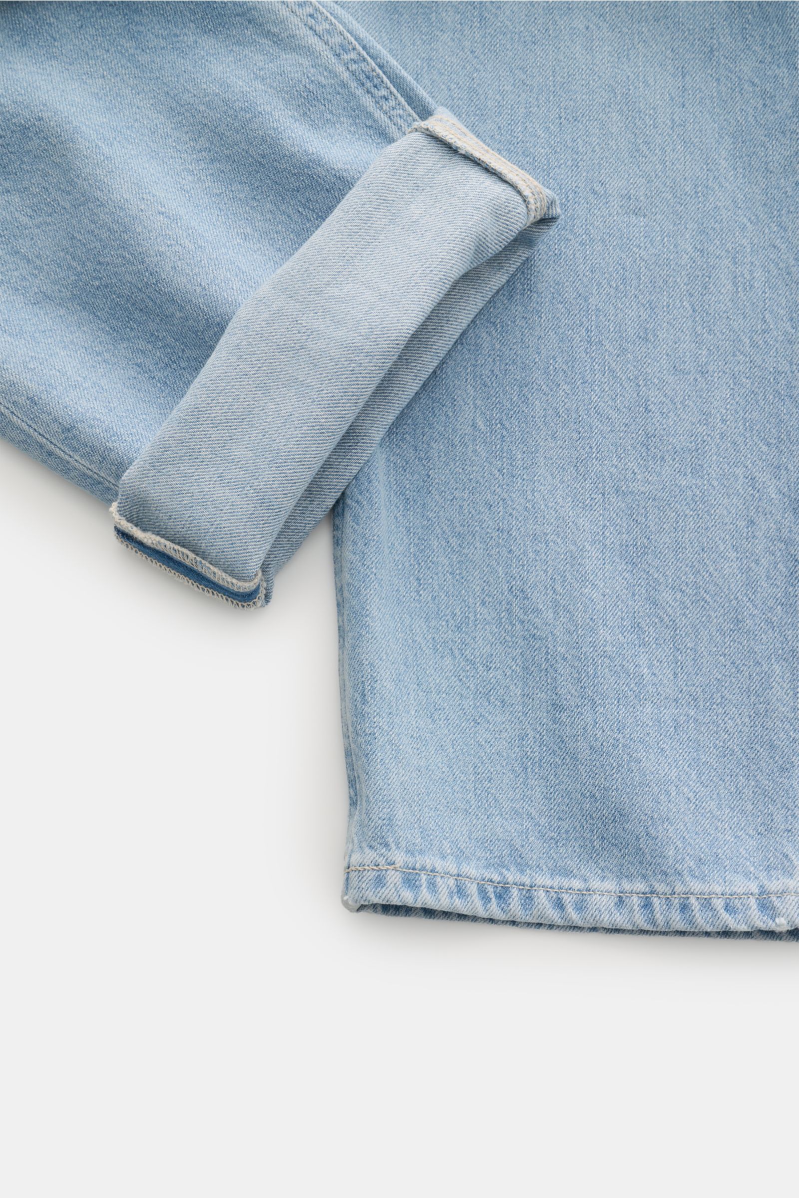 Close-up front view of Dondup Jeans 'Bray' hellblau in light blue denim with rolled-up cuff, showing authentic used wash and soft cotton fabric.