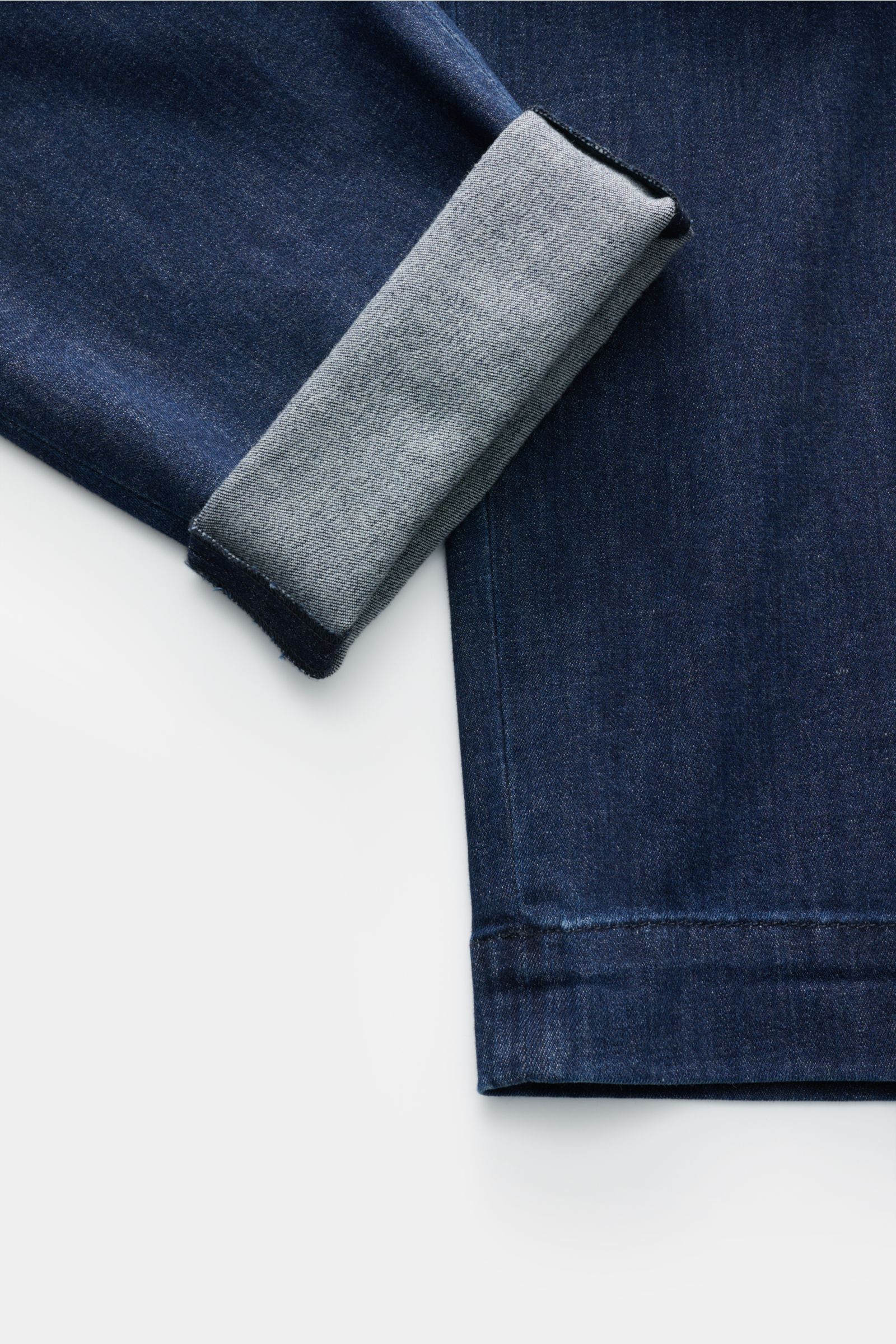 Dark blue Moorer Jeans 'Wilton' close-up from the side, showing folded cuff revealing soft, lightweight Japanese denim with tapered fit.