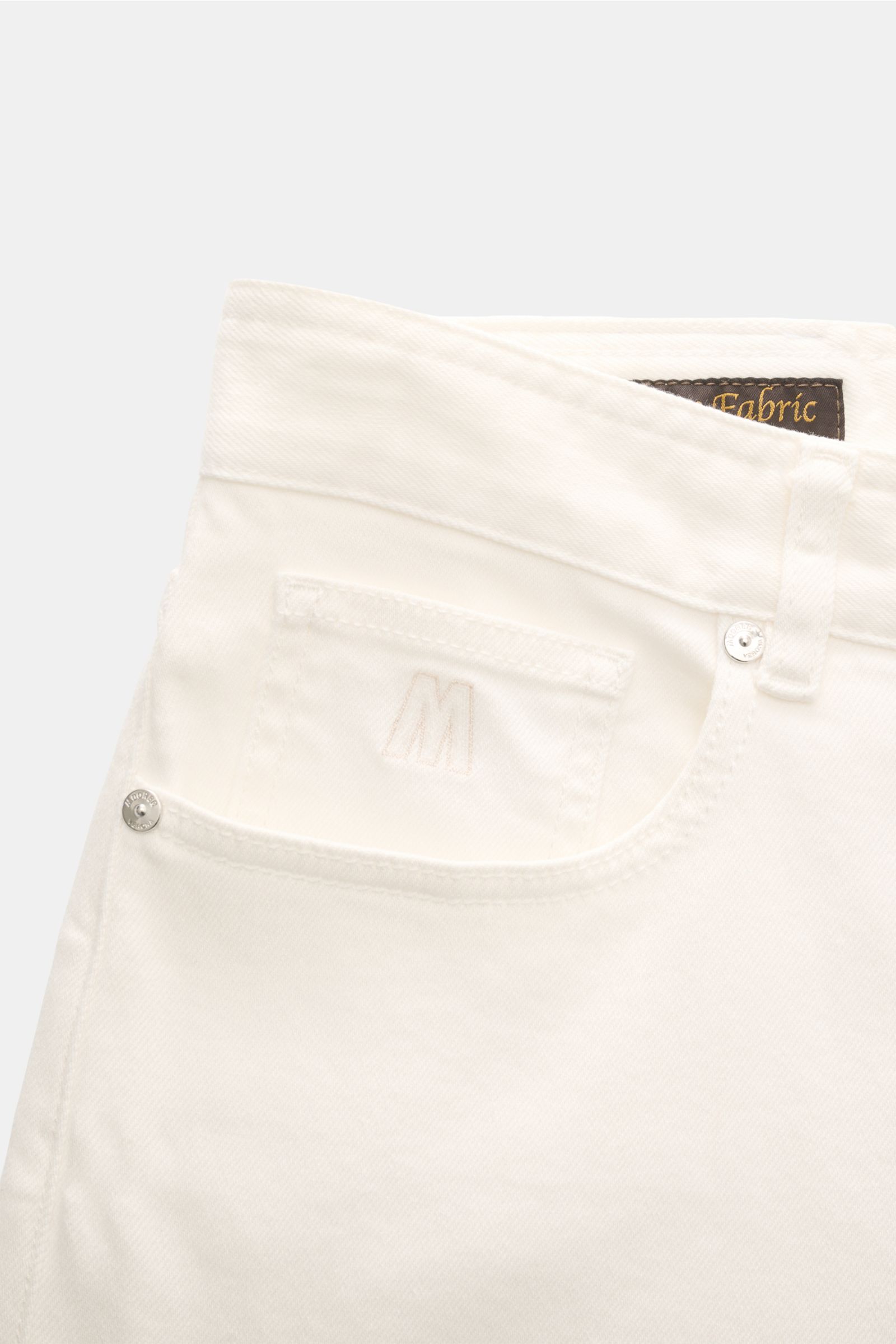 Close-up front view of Moorer Jeans 'Milton' off-white showing stretchy cotton denim, button fly, five-pocket style, embroidered coin pocket, and leather patch. For casual denim looks: The 'Milton' jeans by MOORER offer unparalleled comfort and are the id
