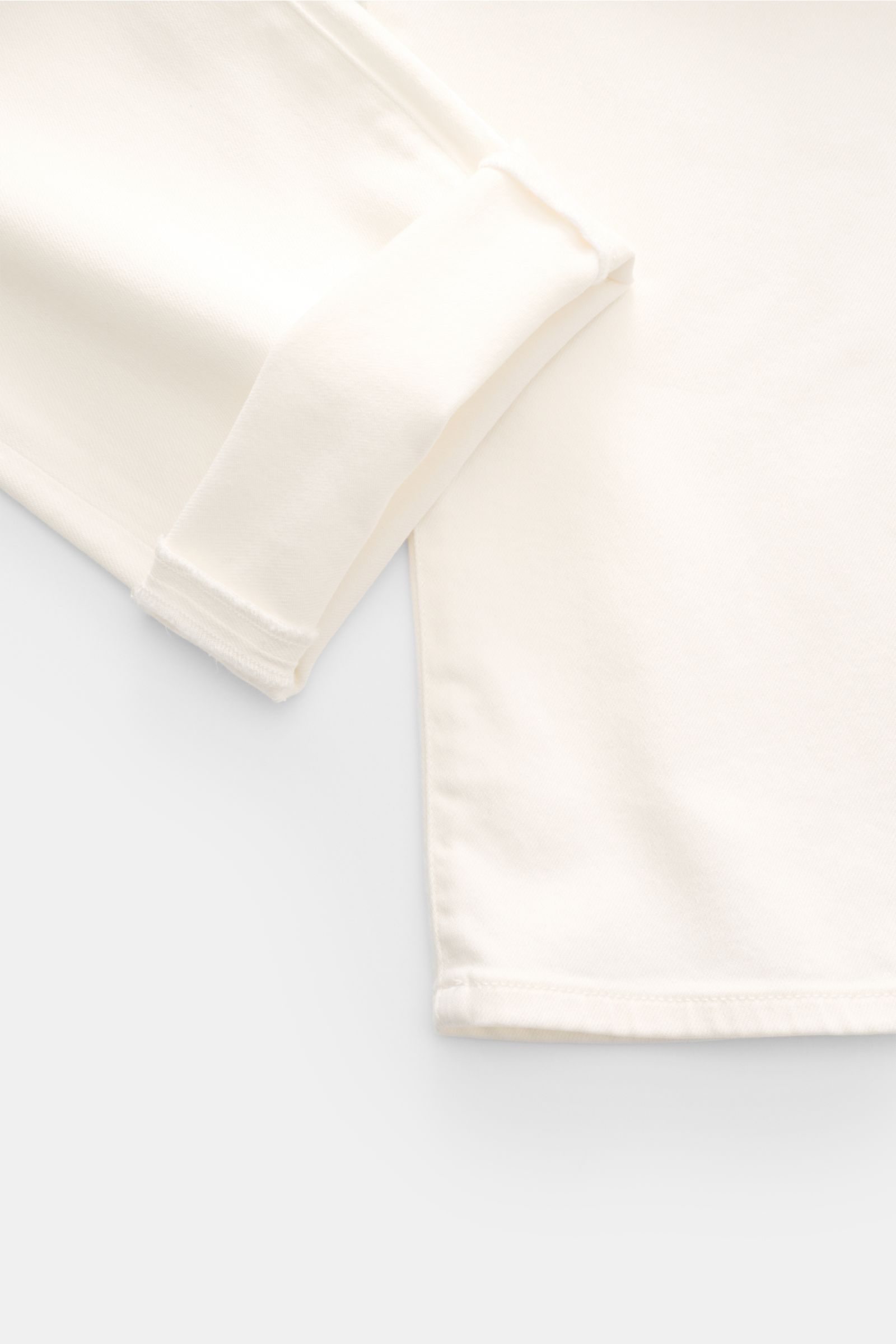 Close-up top view of Moorer Jeans 'Milton' off-white showing folded cuff and hem in stretchy cotton denim with soft feel and subtle wash, regular fit, straight cut, button fly, five-pocket style, coin pocket with embroidered logo, back pockets with stitch