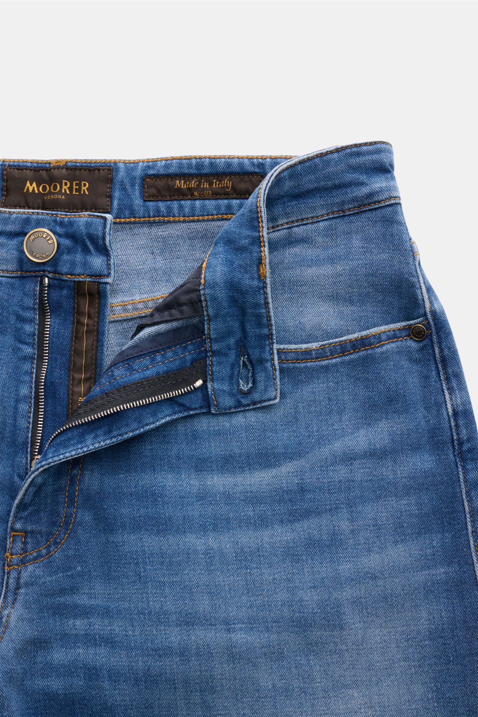 Close-up front view of Moorer Jeans 'Milton' rauchblau in blue denim with button fly, coin pocket with logo, and soft elastic cotton fabric. For casual denim looks: The 'Milton' jeans by MOORER offer unmatched comfort and are an ideal basic for relaxed le