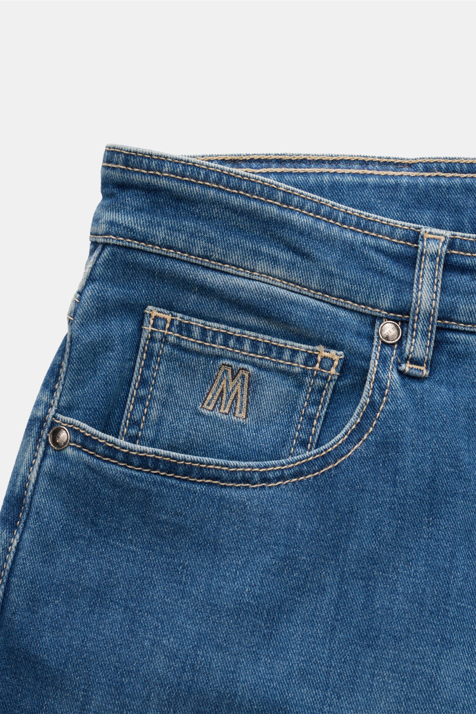 Close-up front side view of the Moorer Jeans 'Milton' rauchblau in regular fit denim with soft touch, button fly, five-pocket style, coin pocket with embroidered 'M' logo, and leather patch. For casual denim looks with subtle used wash and straight cut.