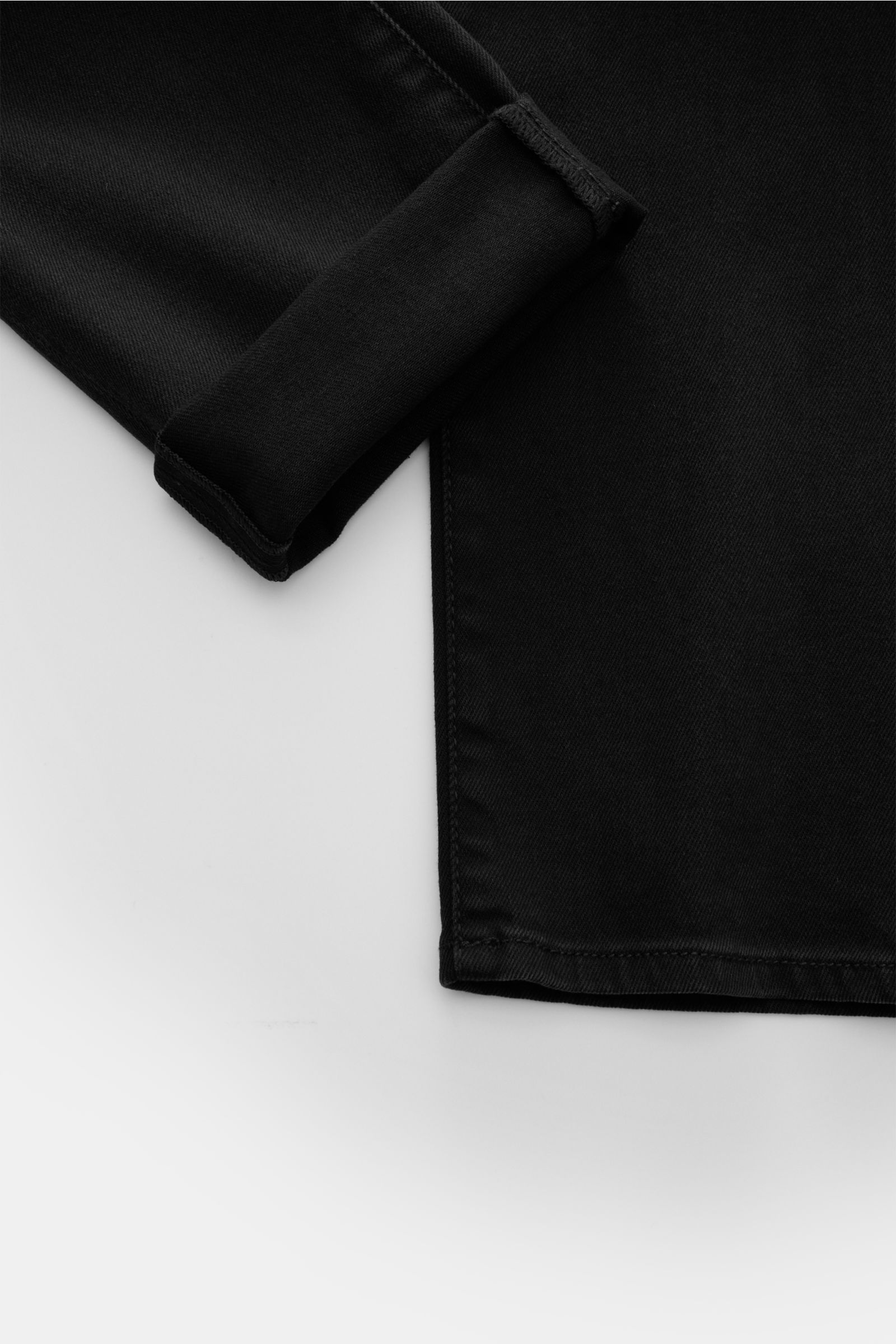 Close-up image of the hem and cuff detail of Jacob Cohen Jeans 'Nick' dunkelgrau, photographed from above, showing denim aus Baumwolle und Microfaser, elastische Qualität, weicher Griff, dezente Used-Waschung, Slim Fit, schmal zulaufend, Button Fly, Five-