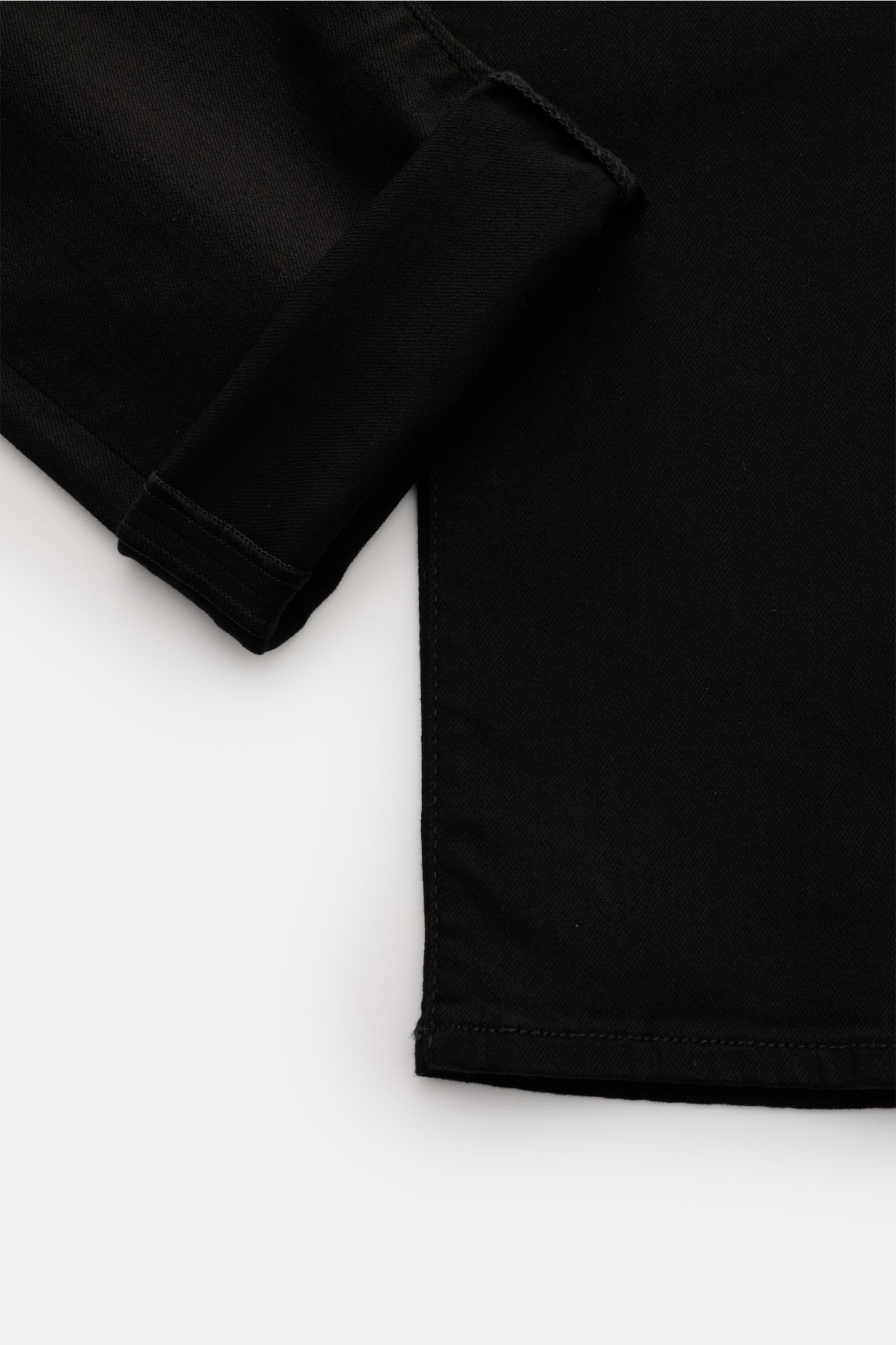 Close-up image of the hem and cuff of Jacob Cohen Jeans 'Nick' black, showing the denim fabric and stitching details. Denim made of cotton and microfibre, elasticated fabric, soft feel, slim fit, tapered cut, button fly, five-pocket style, coin pocket wit