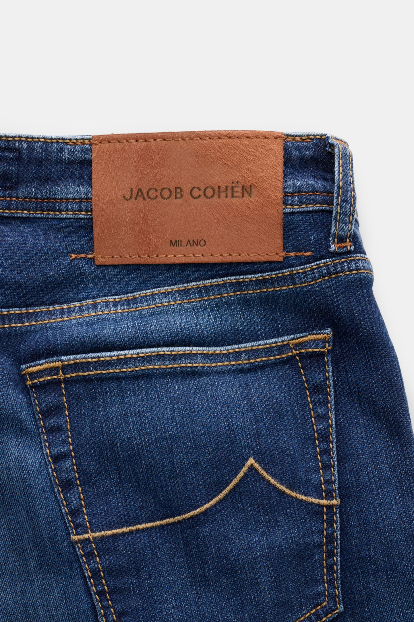 Jacob Cohen Jeans 'Bard' blau shown from the back waist, featuring soft elastic cotton denim with subtle used wash, slim fit, signature stitching, and a distinctive ponyhair-look leather patch.