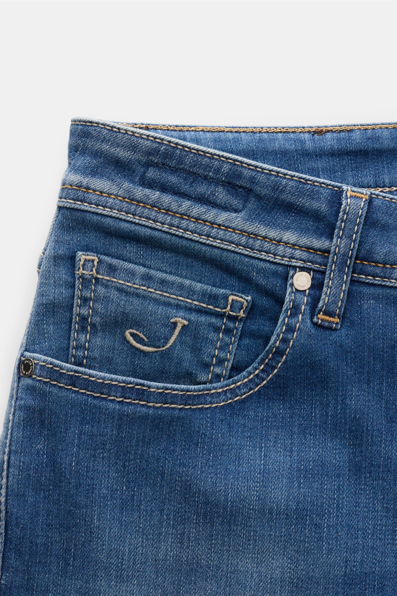 Close-up front view of Jacob Cohen Jeans 'Bard' rauchblau in slim fit, showing soft elastic denim, subtle used wash, coin pocket with 'J' initial, stitching, button fly, and pony hair leather patch. Setzen Sie auf modernen Luxus im Alltag: Die Premium-Jea