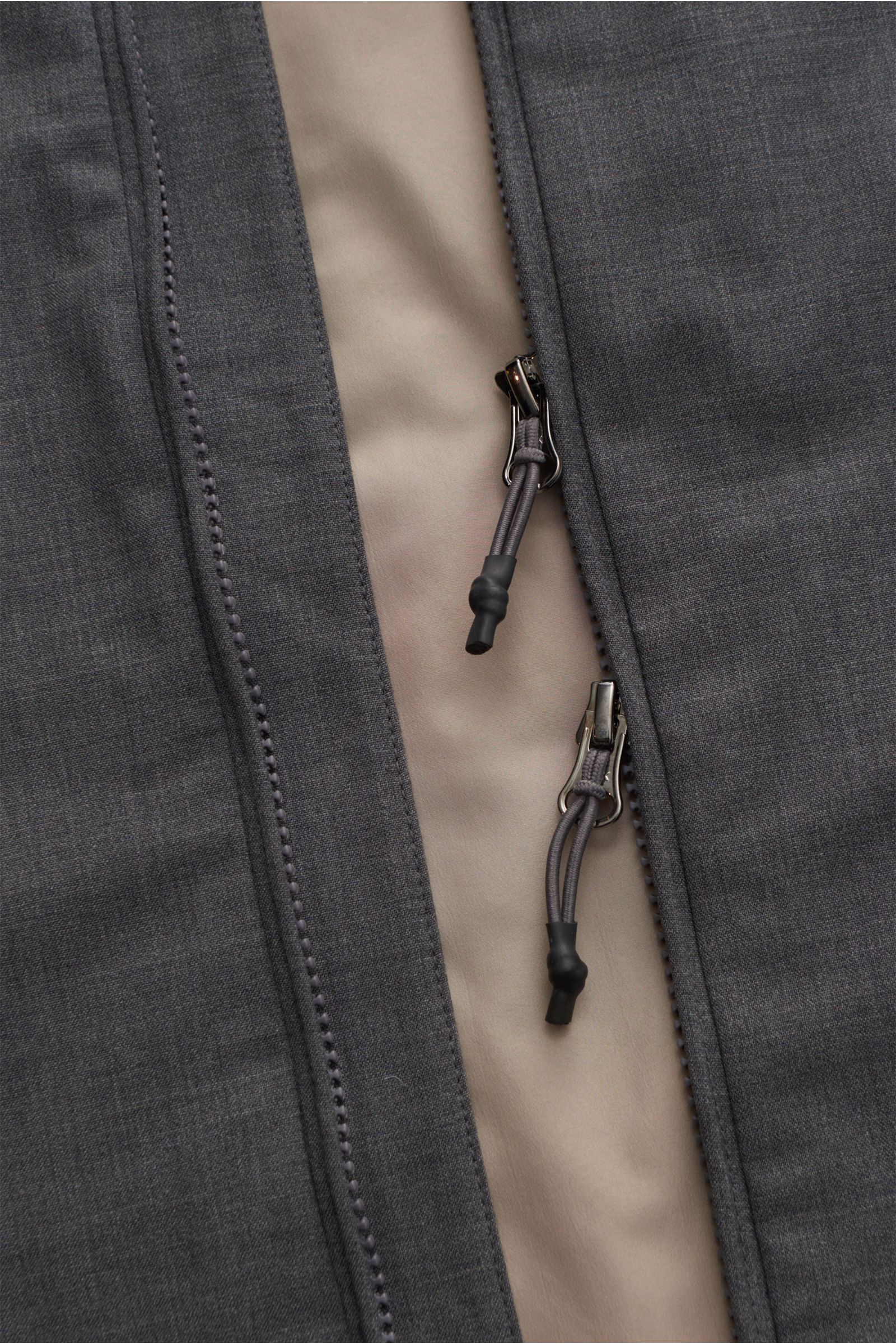 Nahaufnahme der Reißverschlüsse der The Product is the Hero Daunenweste 'A Special Vest' grau meliert, extraleichte Weste aus mulesingfreier Schurwolle mit Daunen-Merino-Füllung, Slim Fit, zwei-Wege-Reißverschluss, Stehkragen mit verstaubarer Kapuze, Leis