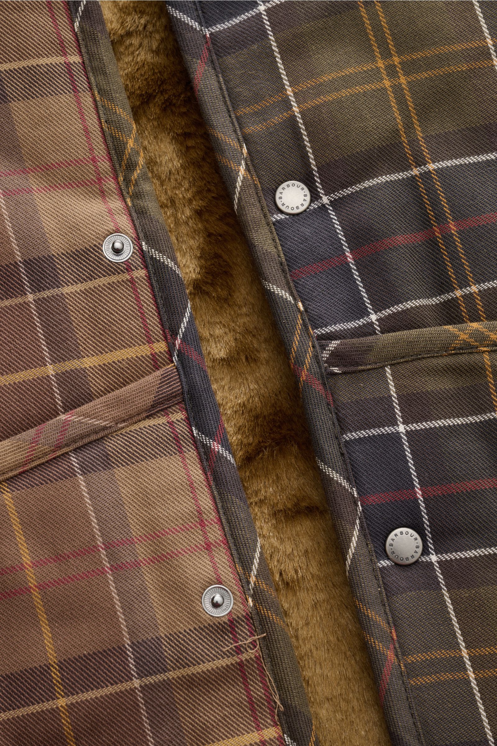Barbour Weste 'Liner' oliv/braun/rot kariert, Nahaufnahme von außen mit Druckknöpfen und weichem Webpelz-Innenfutter sichtbar.