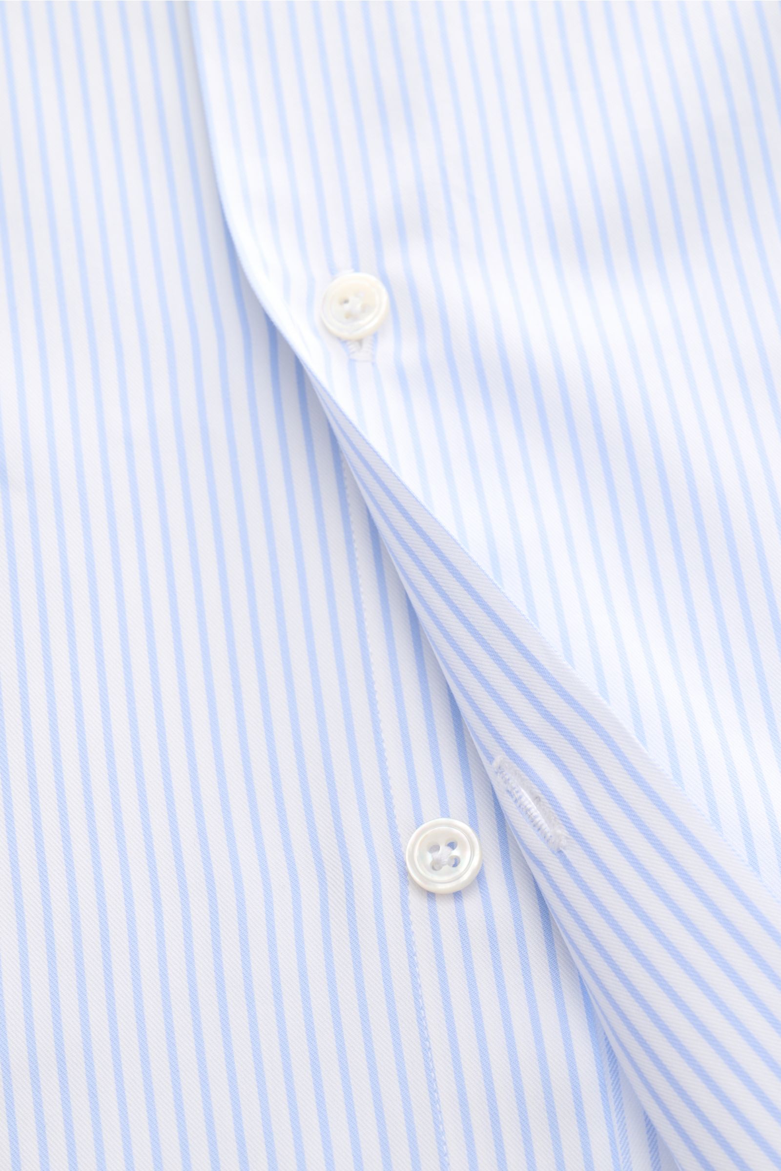 Close-up front view of Finamore Business shirt 'Rodi Napoli' Kent collar light blue/white striped, showing fine cotton gabardine fabric with smooth feel, slim fit, extra-long sleeves, Kent collar, French button placket, classic barrel cuffs, and rounded h