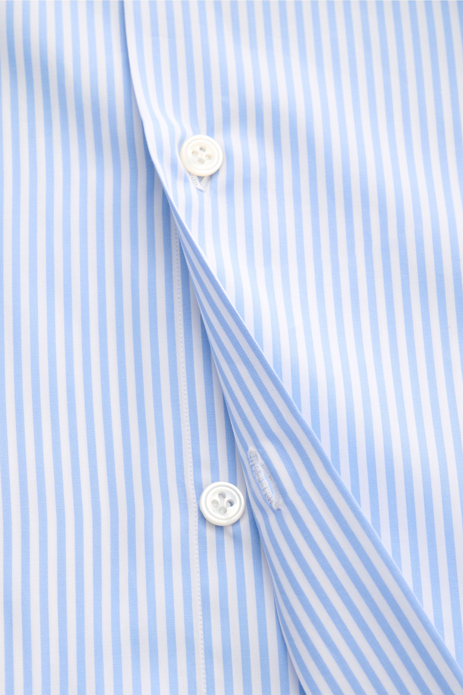 Close-up front view of Finamore Business shirt 'Rodi Napoli' Kent collar light blue/white striped, showing cotton poplin fabric, smooth feel, slim fit, extra-long sleeves, Kent collar, French button placket, classic barrel cuffs, and rounded hem.