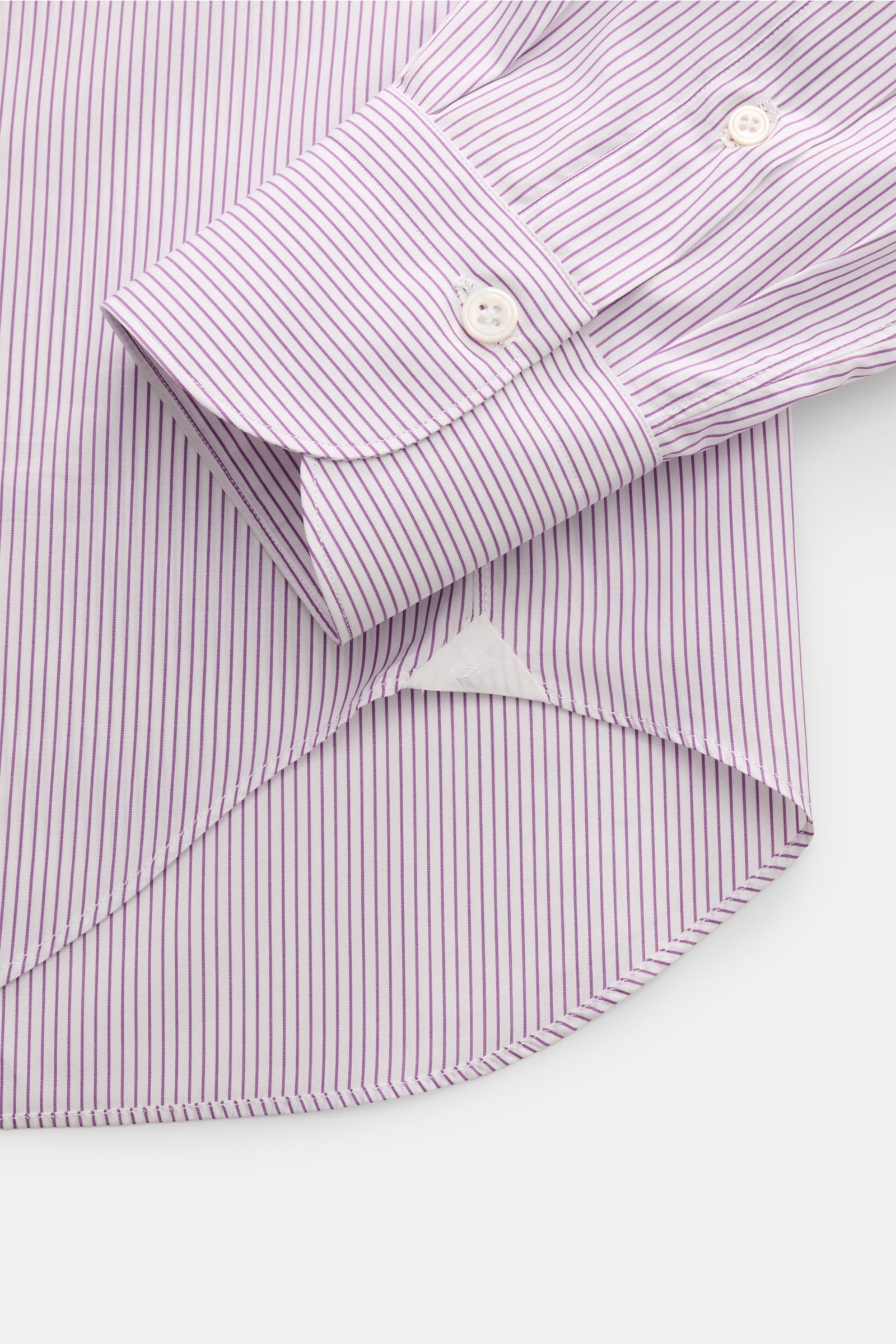 Nahaufnahme des gerundeten Saumverlaufs und der klassischen Sportmanschette des Finamore Business Hemd 'Sergio Milano' Haifisch-Kragen violett/weiß gestreift aus reiner, kühlender Baumwolle mit französischer Knopfleiste und Perlmuttknöpfen in Extra Slim F