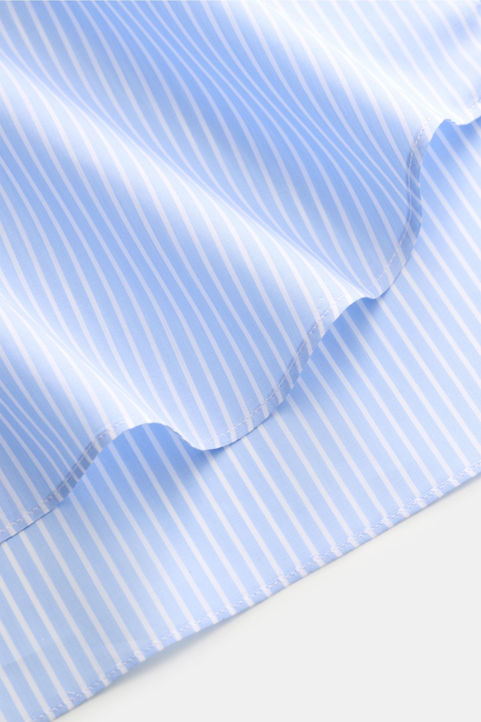 Nahaufnahme des gerundeten Saumverlaufs des Finamore Business Hemd 'Sergio Milano' Haifisch-Kragen hellblau/weiß gestreift aus reiner Baumwolle, Extra Slim Fit, kühlem, glattem Griff, französischer Knopfleiste mit Perlmuttknöpfen und klassischer Sportmans