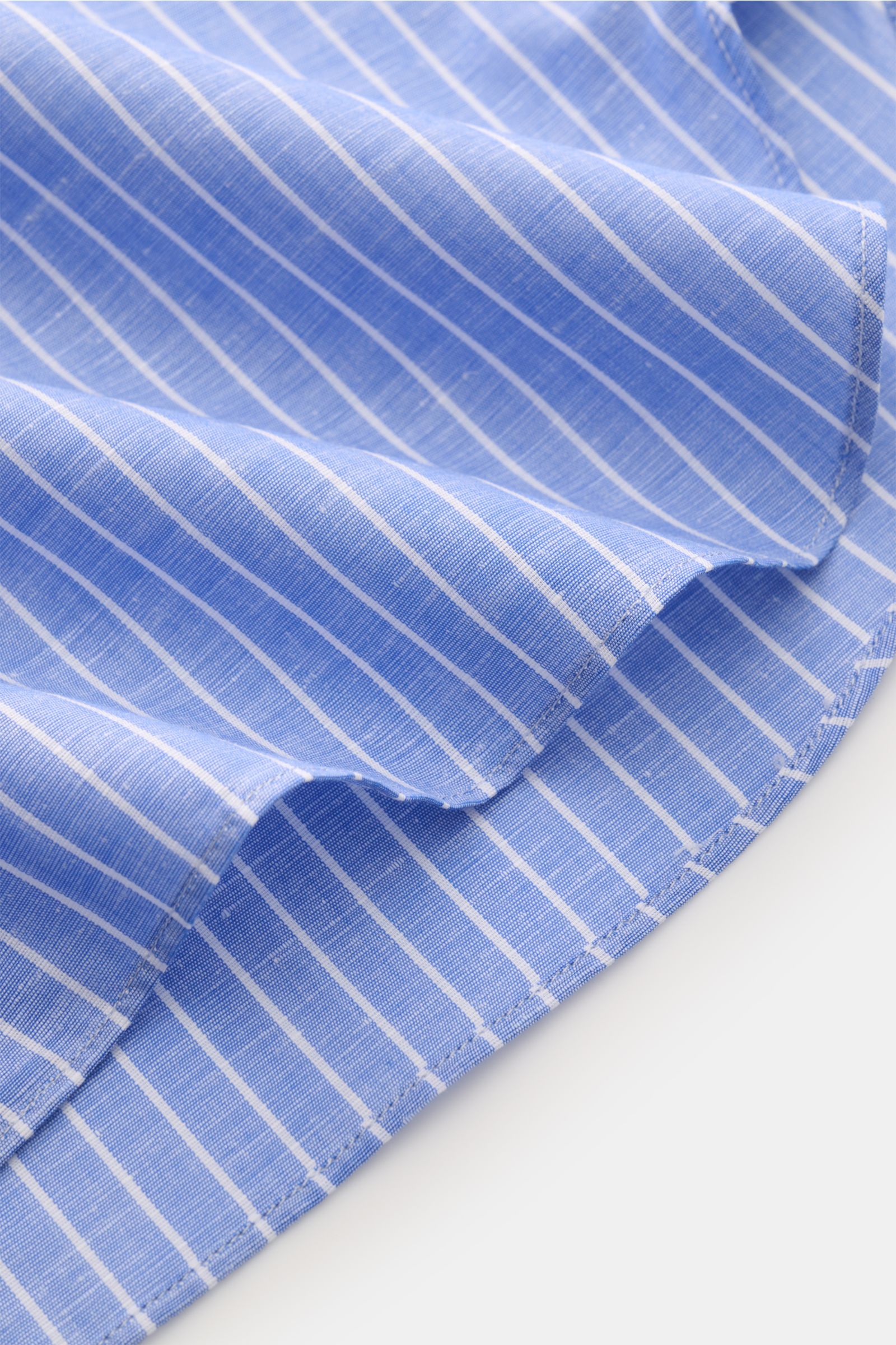 Close-up of Borrelli Business shirt 'Luciano' Kent collar white/blue striped fabric showing the fine linen-cotton blend with a light, smooth touch and timeless striped pattern from a side angle.