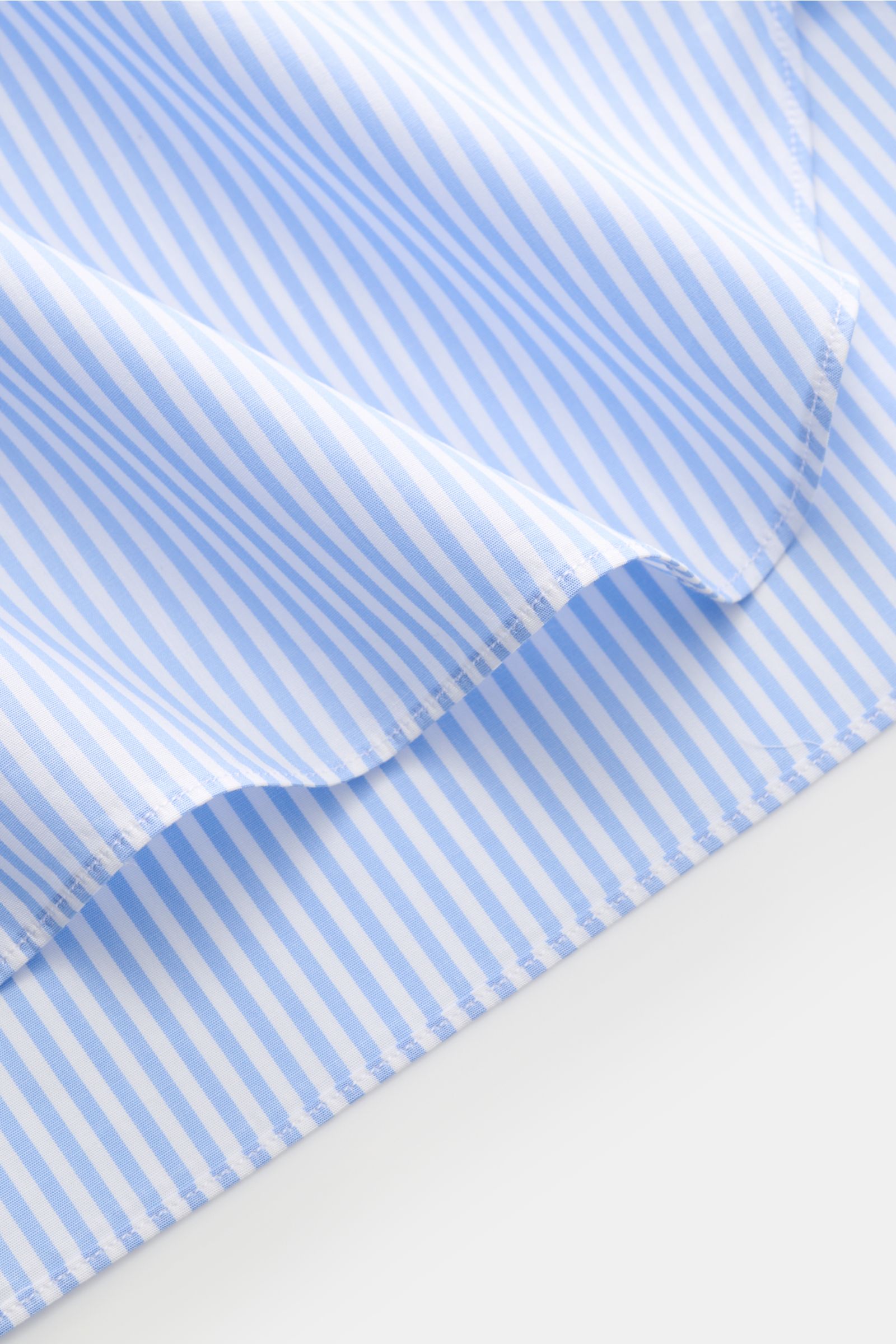 Borrelli Business Hemd 'Nando' Haifisch-Kragen hellblau/weiß gestreift in Slim Fit, reine Baumwolle, glatter Griff, klassische Sportmanschette, gerundeter Saum, Ansicht Detail Stoff und Naht.