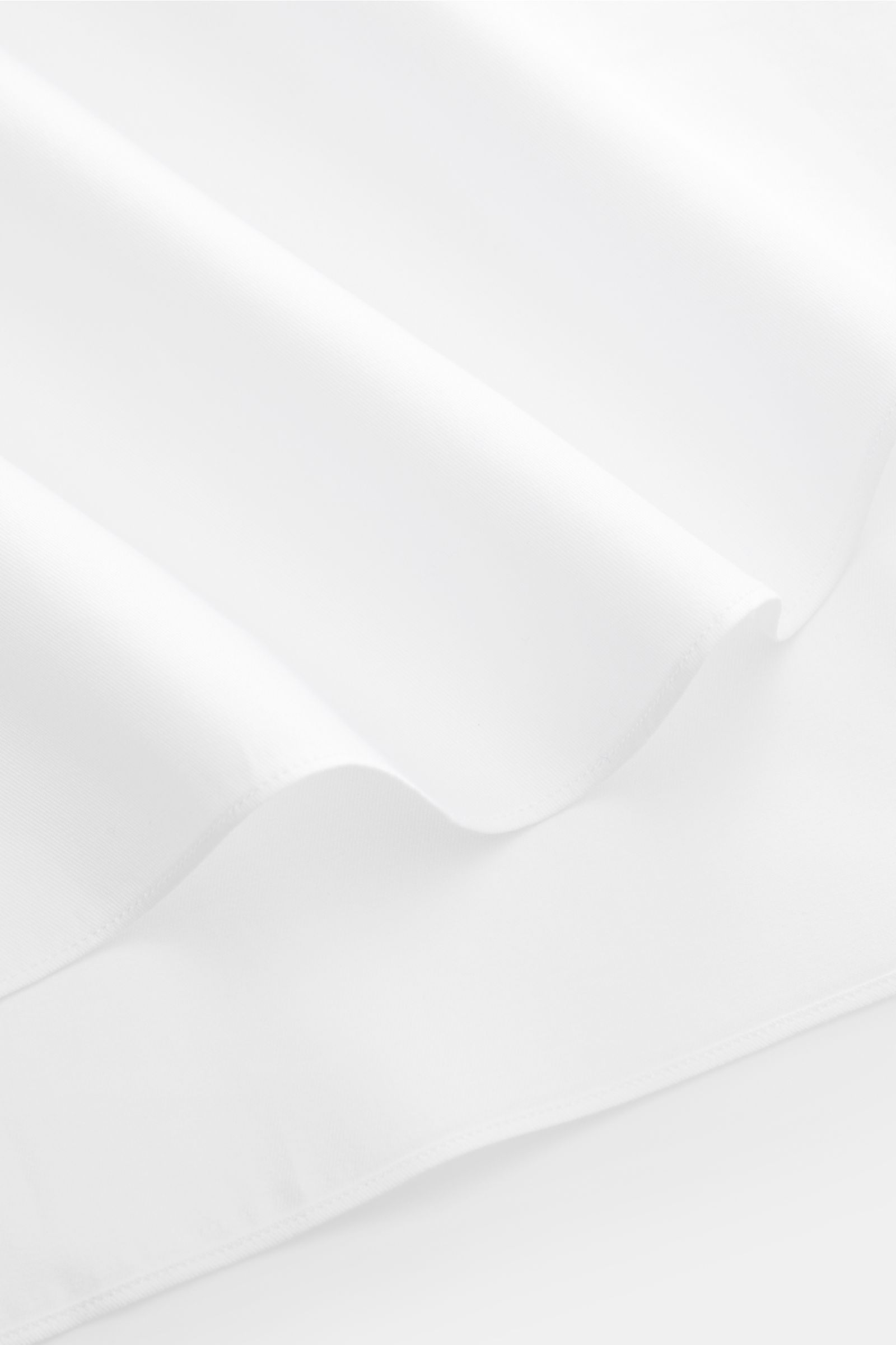 White fabric close-up photographed from above, showing texture and folds of the Gherardi Business shirt shark collar white made of pure cotton gabardine, smooth touch, lightweight fabric, slim fit, shark collar, French button placket, classic barrel cuffs