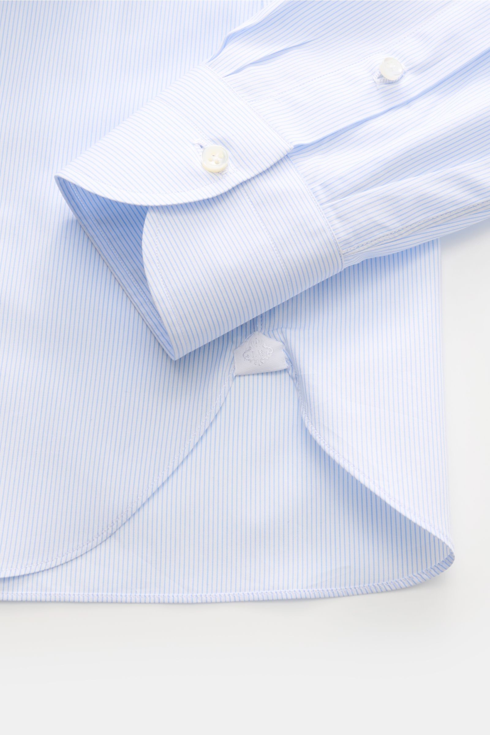 Close-up top view of the Borrelli Business Hemd 'Nando' Haifisch-Kragen hellblau/weiß gestreift, showing the cuff and curved hem. Popeline aus reiner Baumwolle, leichter, glatter Griff, klassisches Streifenmuster, Slim Fit, Haifisch-Kragen, französische K