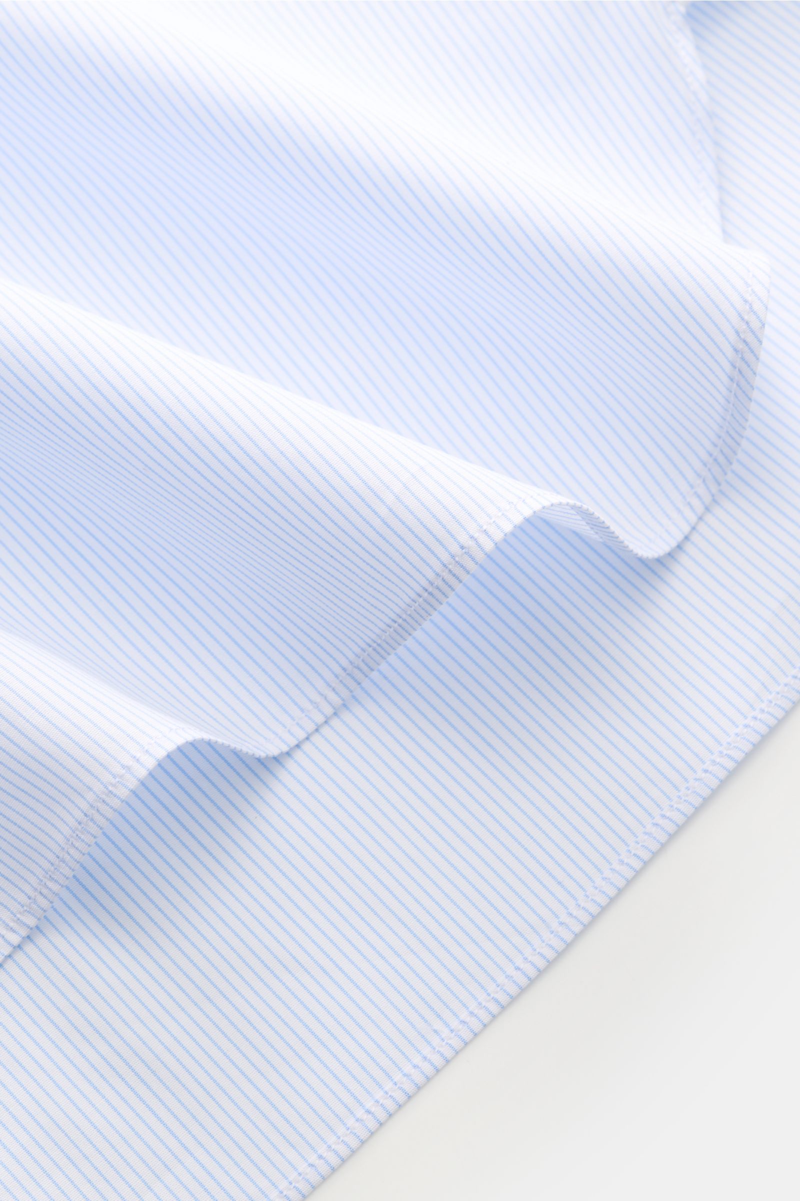 Close-up view of fabric detail from the Borrelli Business Hemd 'Nando' Haifisch-Kragen hellblau/weiß gestreift, showing popeline aus reiner Baumwolle, leichter glatter Griff, klassisches Streifenmuster, Slim Fit, Haifisch-Kragen, französische Knopfleiste 