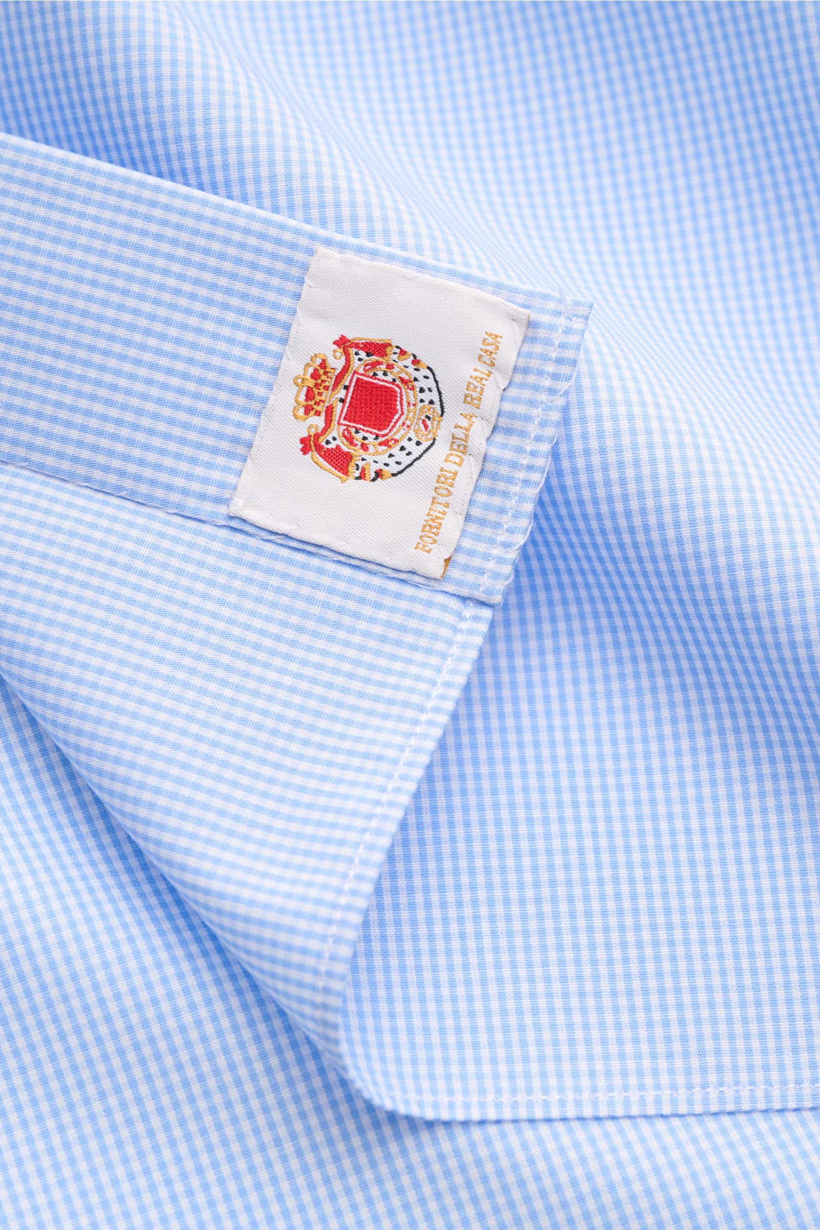 Borrelli Business Hemd 'Nando' Haifisch-Kragen hellblau/weiß kariert, Popeline Baumwolle, leichter Griff, feines Karomuster, Slim Fit, französische Knopfleiste mit Perlmuttknöpfen, Sportmanschette, gerundeter Saum, Detailaufnahme von oben.