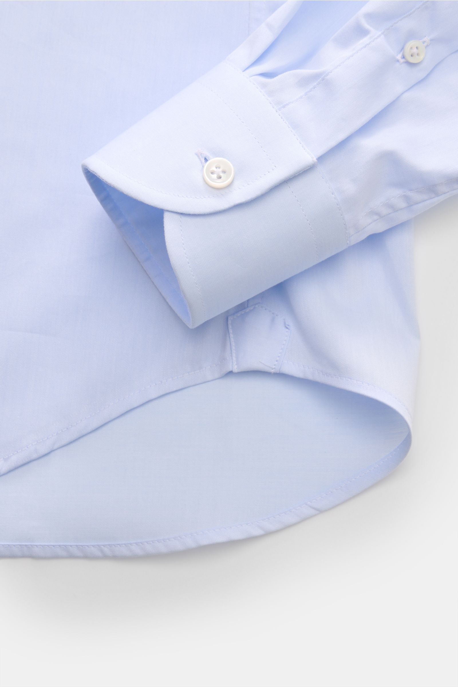 BRAUN Hamburg Business Hemd Haifisch-Kragen hellblau, Detailaufnahme von Manschette und Saum, feiner Baumwoll-Gabardine, glatter Griff, Extra Slim Fit, französische Knopfleiste, klassische Sportmanschette, gerundeter Saumverlauf.