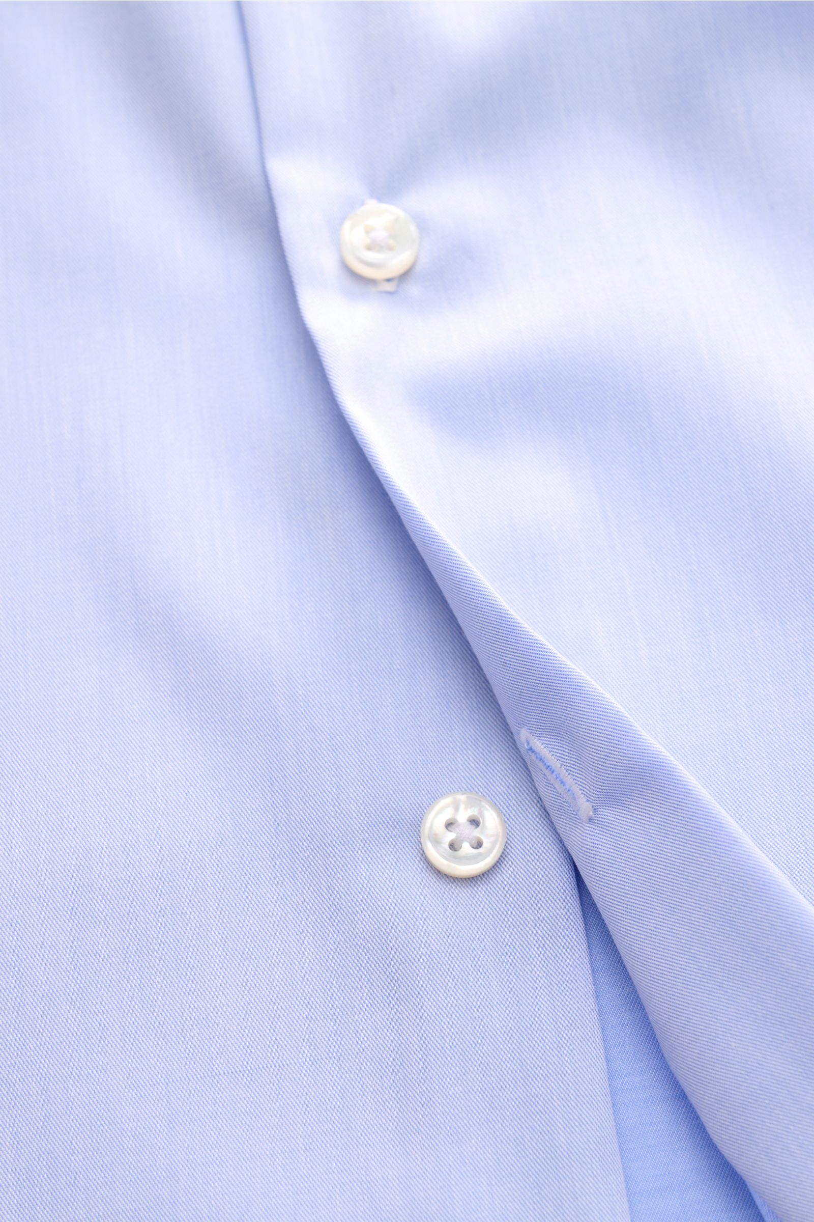 Nahaufnahme aus schräger Perspektive des BRAUN Hamburg Business Hemd Haifisch-Kragen hellblau, feiner Baumwoll-Gabardine, weicher Griff, Extra Slim Fit mit französischer Knopfleiste, klassischer Sportmanschette, rückwärtigen Taillenabnähern und gerundetem