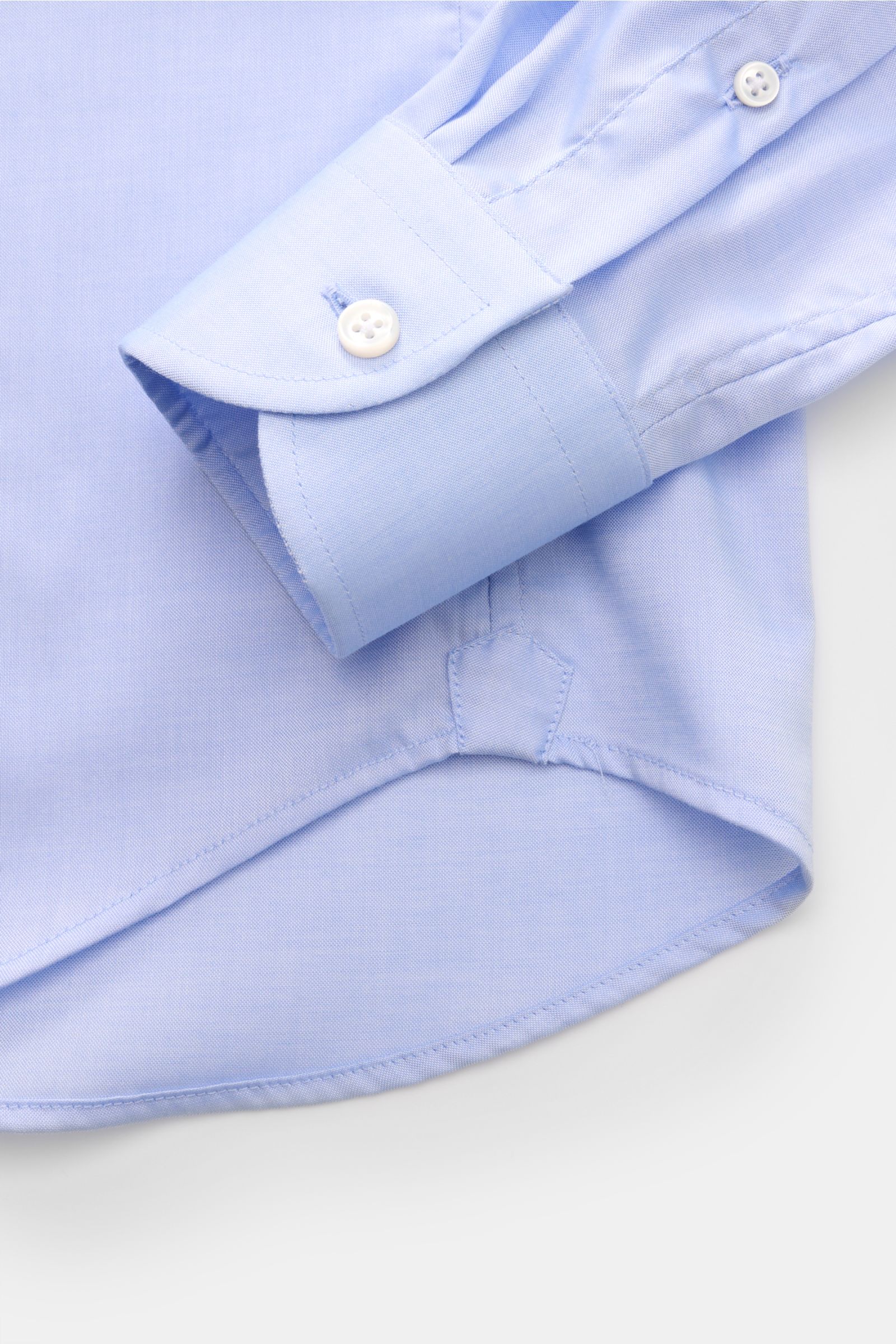 Nahaufnahme des Ärmels und Saums vom BRAUN Hamburg Business Hemd Haifisch-Kragen hellblau, feiner Gabardine aus Baumwolle, weicher Griff, Extra Slim Fit, französische Knopfleiste, klassische Sportmanschette, rückwärtige Taillenabnäher, gerundeter Saumverl