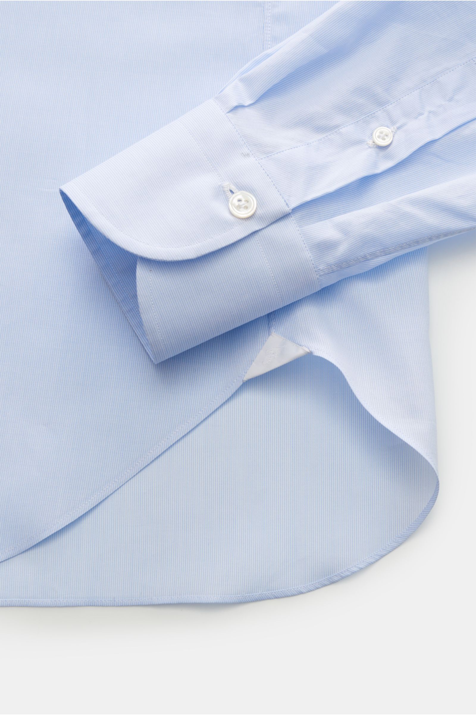 Close-up photo of the sleeve and curved hem of the Finamore Business Hemd 'Sergio Napoli' Haifisch-Kragen hellblau/weiß gestreift, showcasing the slim fit poplin cotton fabric with fine stripes, French placket, extra-long sleeves, classic sport cuff, and 