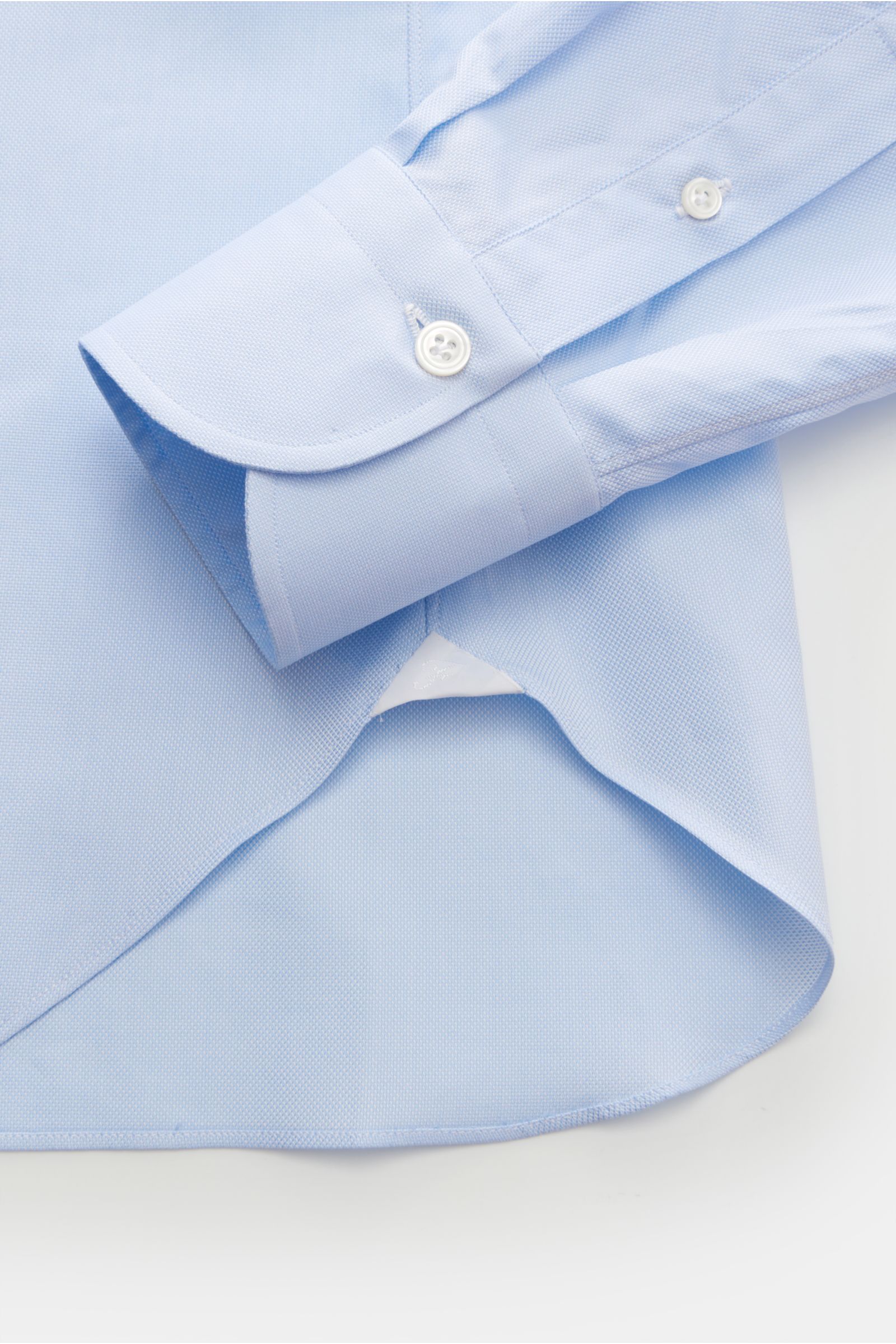 Close-up top view of the sleeve and hem of the Finamore Business Hemd 'Sergio Napoli' Haifisch-Kragen hellblau, showcasing its Oxford cotton fabric and classic design. 

Stilsicher im Office: Das 'Sergio Napoli' Hemd von FINAMORE überzeugt mit seinem k