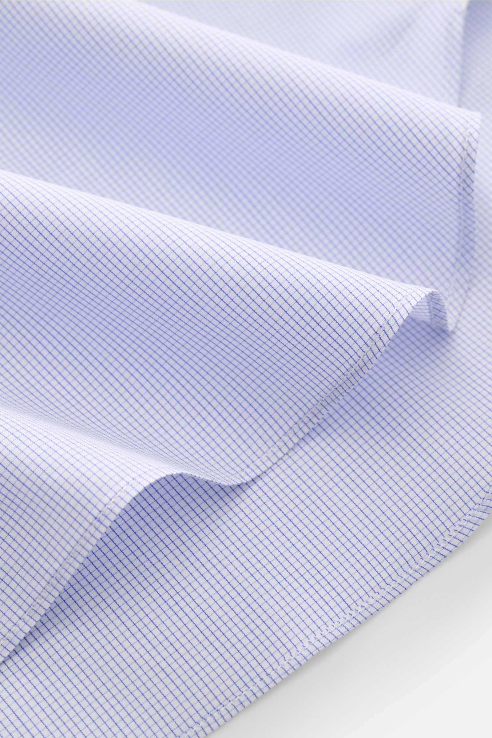 Close-up front view of fabric folds showing the micro checked pattern of the Finamore Business shirt 'Sergio Milano' shark collar blue/white checked, made of soft pure Giza cotton with a smooth touch. Effortlessly create a range of stylish business out