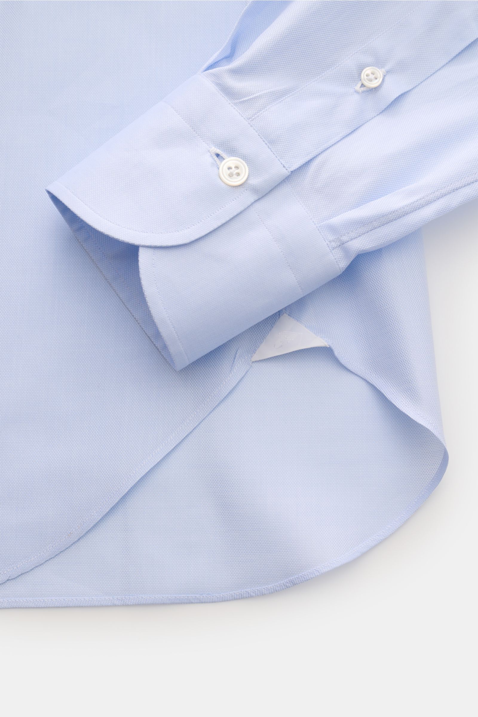 Alt tag (125 characters max):
Close-up of the Finamore Business shirt 'Edoardo Napoli' shark collar light blue showing cuff and rounded hem from a top angle.

Description:
Stylish classic: The shirt 'Edoardo Napoli' from FINAMORE made of soft Giza cott