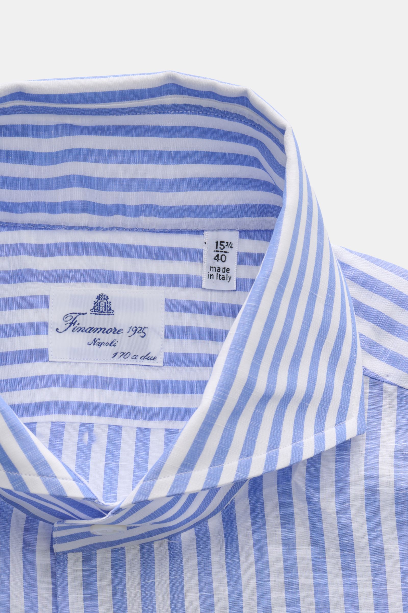 Nahaufnahme von Finamore Business Hemd 'Sergio Napoli' Haifisch-Kragen blau/weiß gestreift, schmale Silhouette, Leinen-Baumwollmix, klassisches Streifendesign, weicher Griff, feine Webstruktur, fotografiert aus leichter Vogelperspektive.