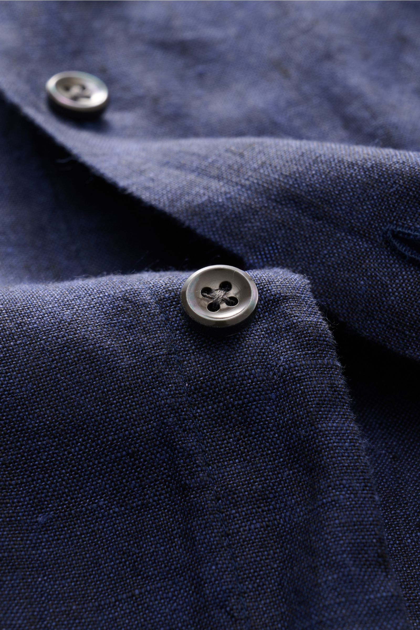 Close-up front-angle view of navy linen fabric with buttons on the von Braun Leinenhemd Haifisch-Kragen navy, showcasing texture and softness. Mühelose Leichtigkeit: Dieses VON BRAUN Hemd aus reinem Leinen überzeugt mit luftigem Tragegefühl und entspannte