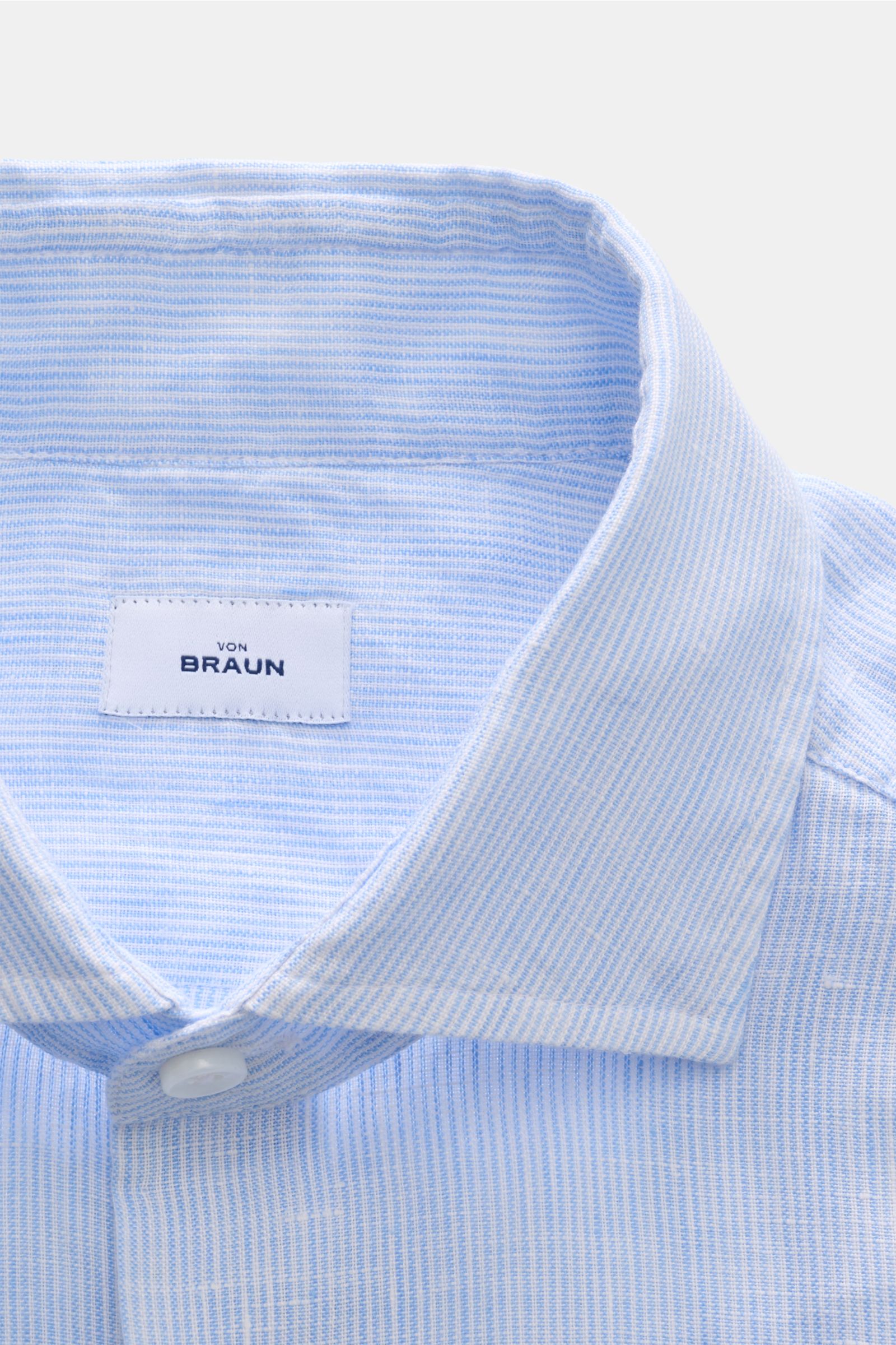 Close-up front view of von Braun Leinenhemd Haifisch-Kragen hellblau/weiß gestreift, pure linen, airy texture, shark collar, fine stripes, slim fit. Mühelose Leichtigkeit: Dieses VON BRAUN Hemd aus reinem Leinen überzeugt mit luftigem Tragegefühl und ents